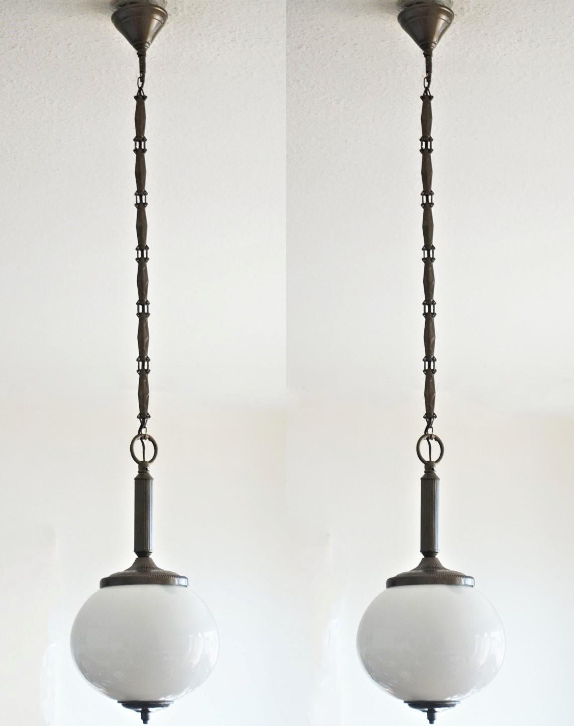Pareja de colgantes italianos globo de opalina soplados a mano, monturas de latón bruñido, cadena y dosel, 1950-1959.
Cableado europeo con un único portalámparas Edison E-27 de latón y porcelana para bombilla de gran tamaño de 40 W a 60 W (cada