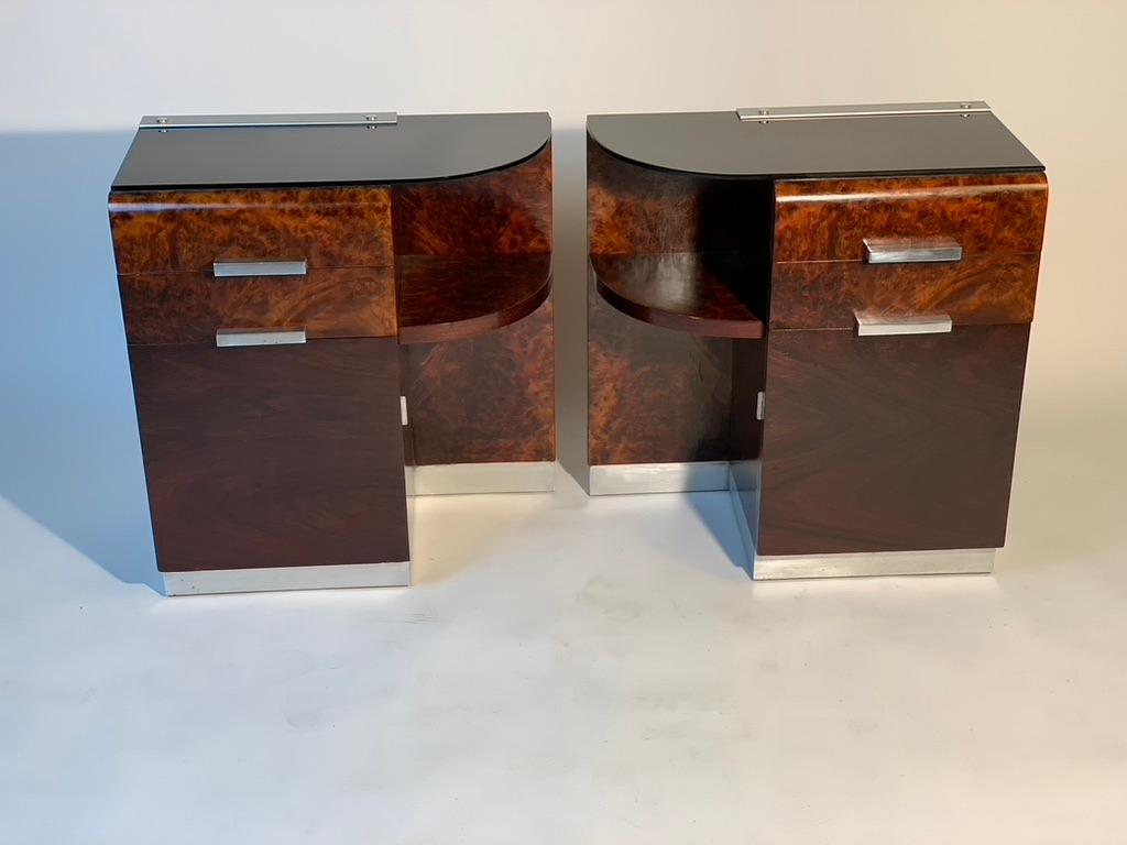 Pair of Italian bedside tables with a half-moon curved side with open compartment, two drawers and a door, all made with beautiful briar details in chromed metal such as the square rod-shaped handles.
The black glass top makes them particularly