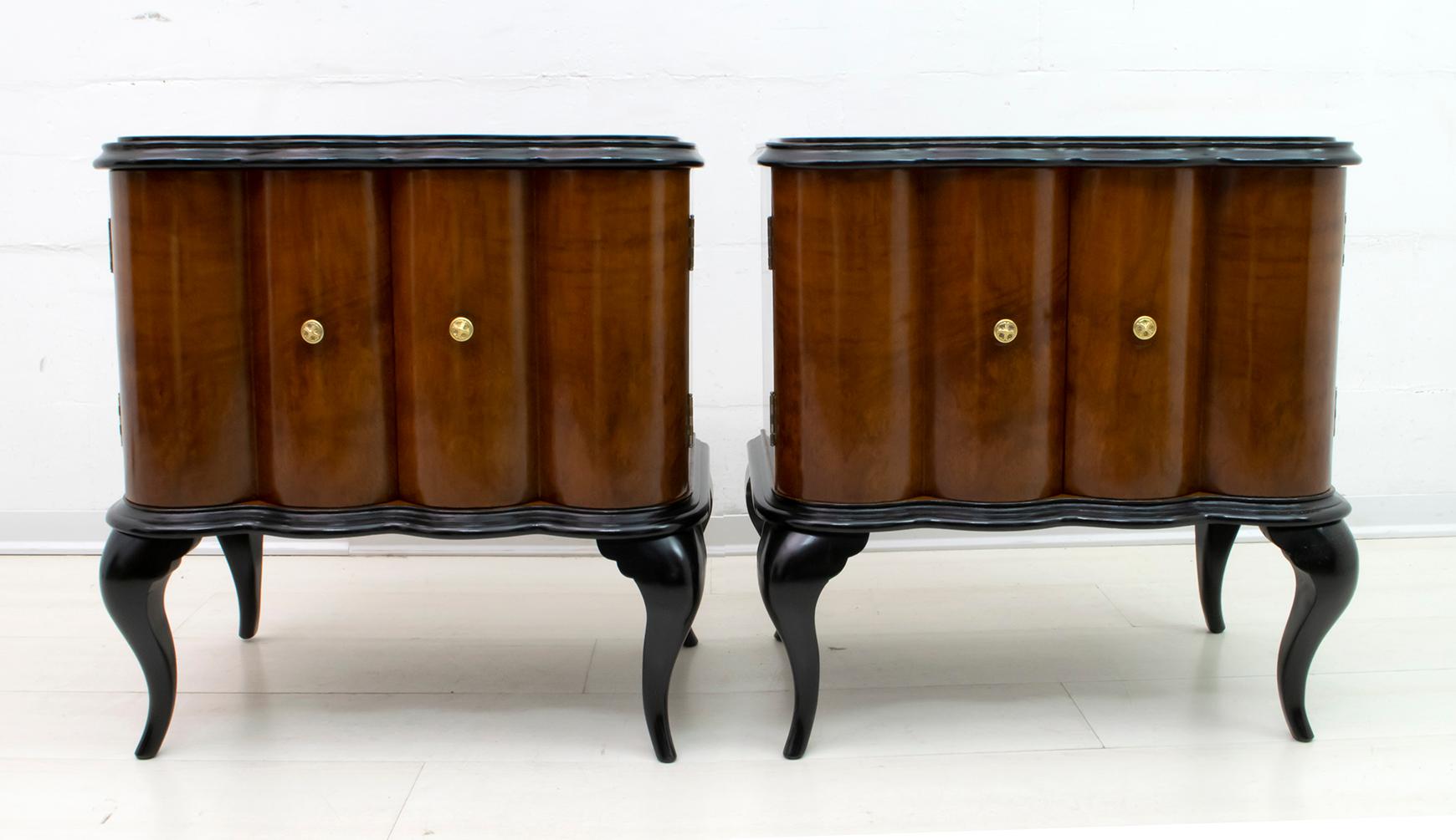 This pair of bedside tables was produced in Italy in the 1920s, Art Deco period. They are covered in national walnut, ebonized wooden feet and frames, the black glass top, the structure is in poplar and the handles are in brass. They have been