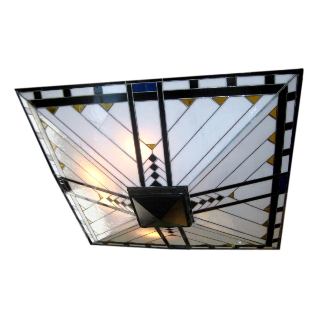 Ce luminaire en verre plombé et vitrail de style Art déco français des années 1930 est suspendu à quatre tiges et à un baldaquin carré.  8 lumières de chadelier.

Mesures :
Hauteur : 36
Longueur/largeur : 28