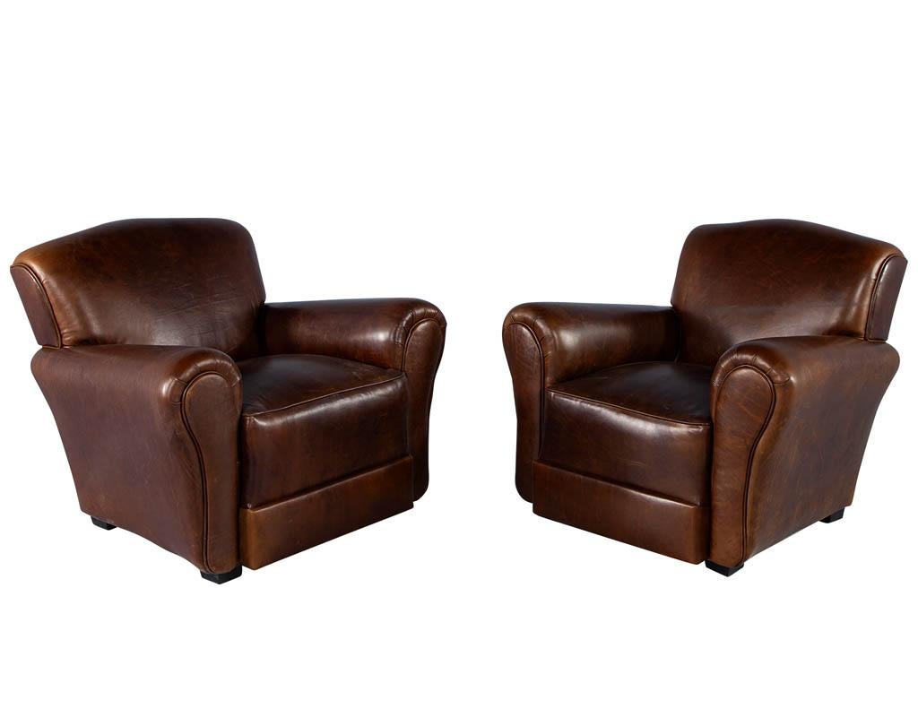 Pair of Art Deco style leather club chairs. France, circa 1950s in original Art Deco design. Masterfully restored in all new Italian leather. Rich elegant tones with beautiful, curved shaping. Completed with a thick seat cushion for comfort and