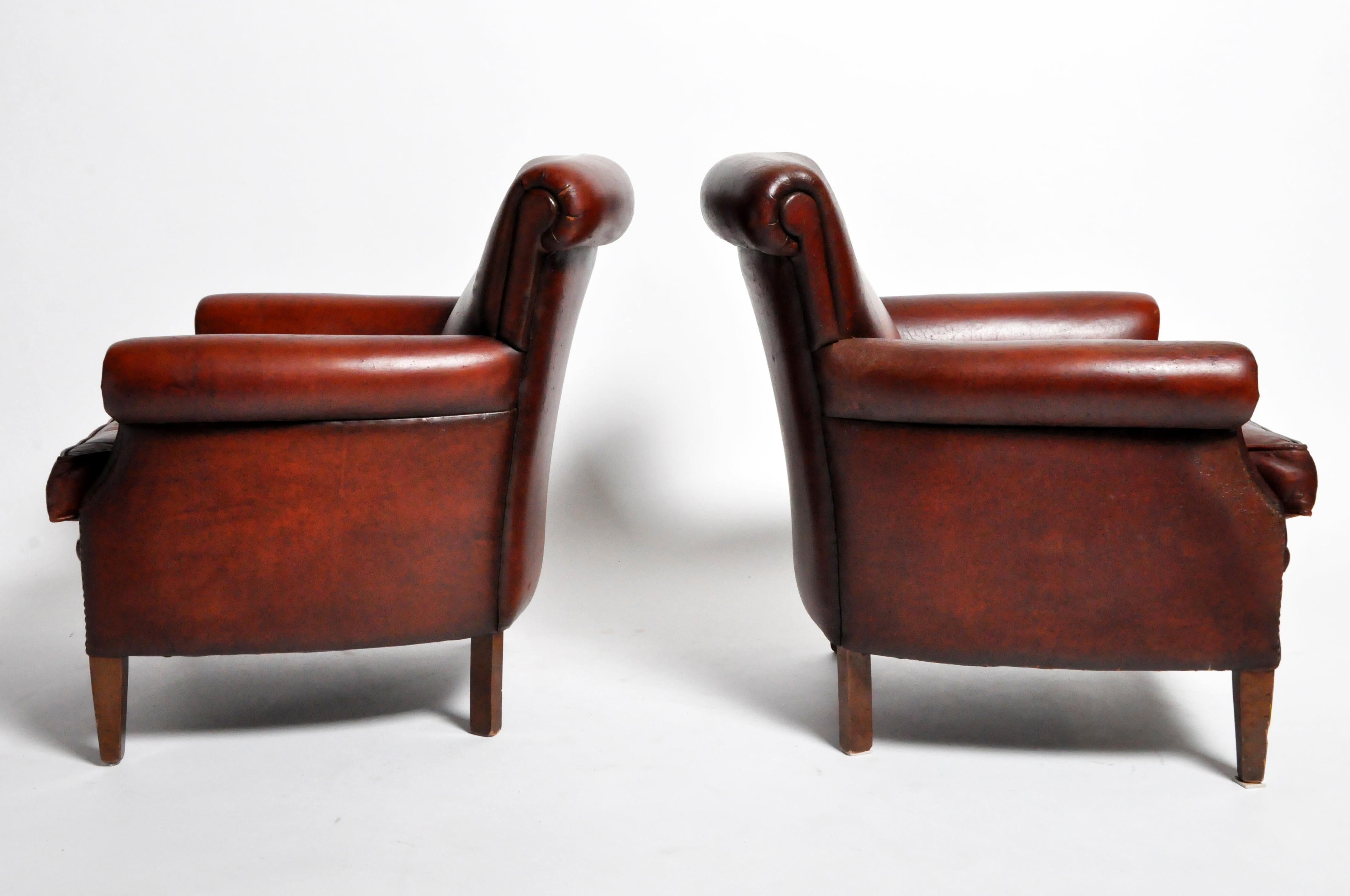 This handsome pair of Art Deco Chairs is from France and made from leather and hardwood. The chairs feature a beautifully aged patina, are comfortable and ready for everyday use. There are some areas of minor repair, consistent with age. Springs