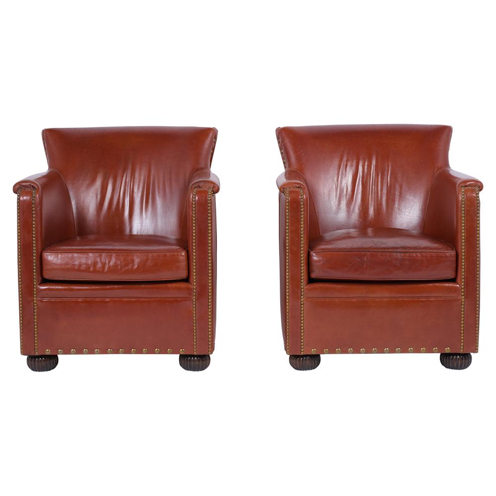 A pair of 1960's Art Deco style Club Chairs crafted out of wood and upholstered in its original leather that's in good condition and dyed in a cognac color with a beautiful patina finish. These extraordinary armchairs feature comfortable barrel