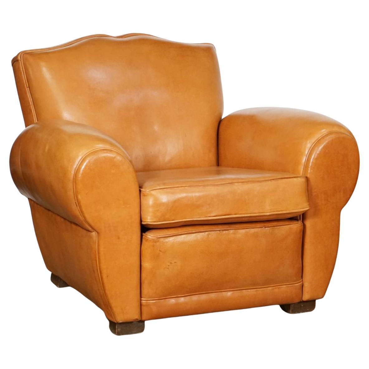 A handsome pair of French club chairs from the Art Deco era, of recently upholstered leather, with beaded trim to the front and sides, nail-head trim round the backs, and cushioned seats, featuring fine lines and deep seating comfort.

Each chair