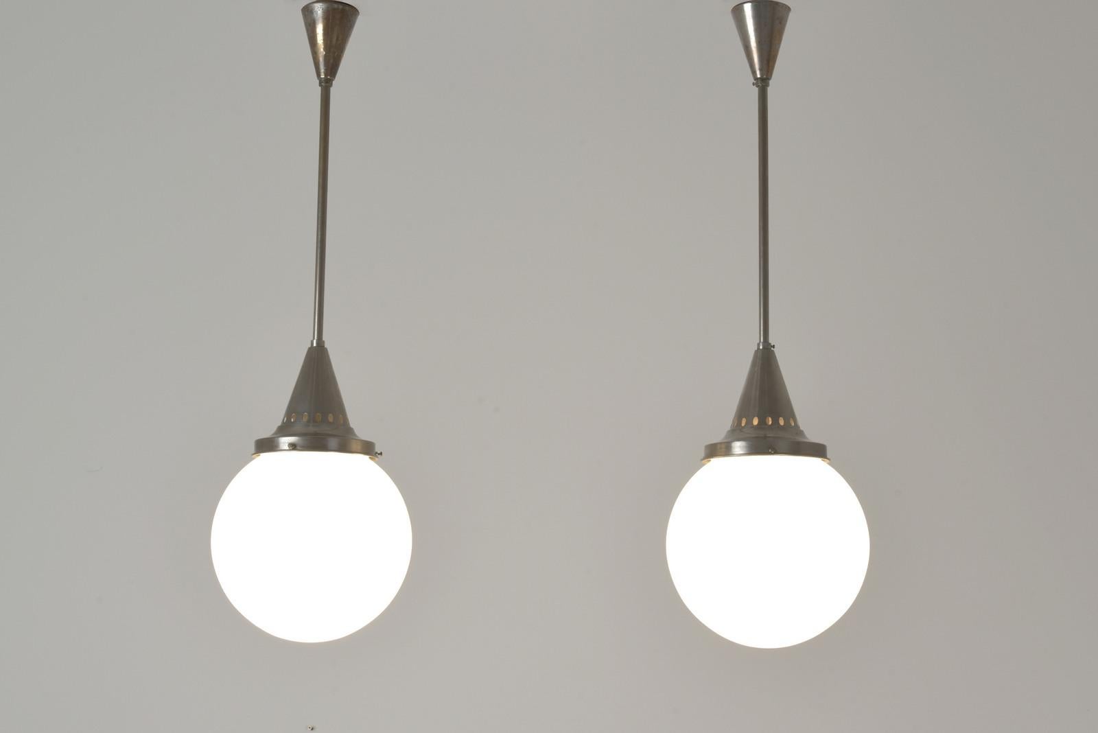 Dimensions: H 83 cm W 23 cm D 23 cm

Material: Nickel-plated brass, molded blown frosted glass, one E 27 bulb each

Condition: Good original condition

Special features: with signs of use. We are offering this beautifully shaped pair of ART-DECO