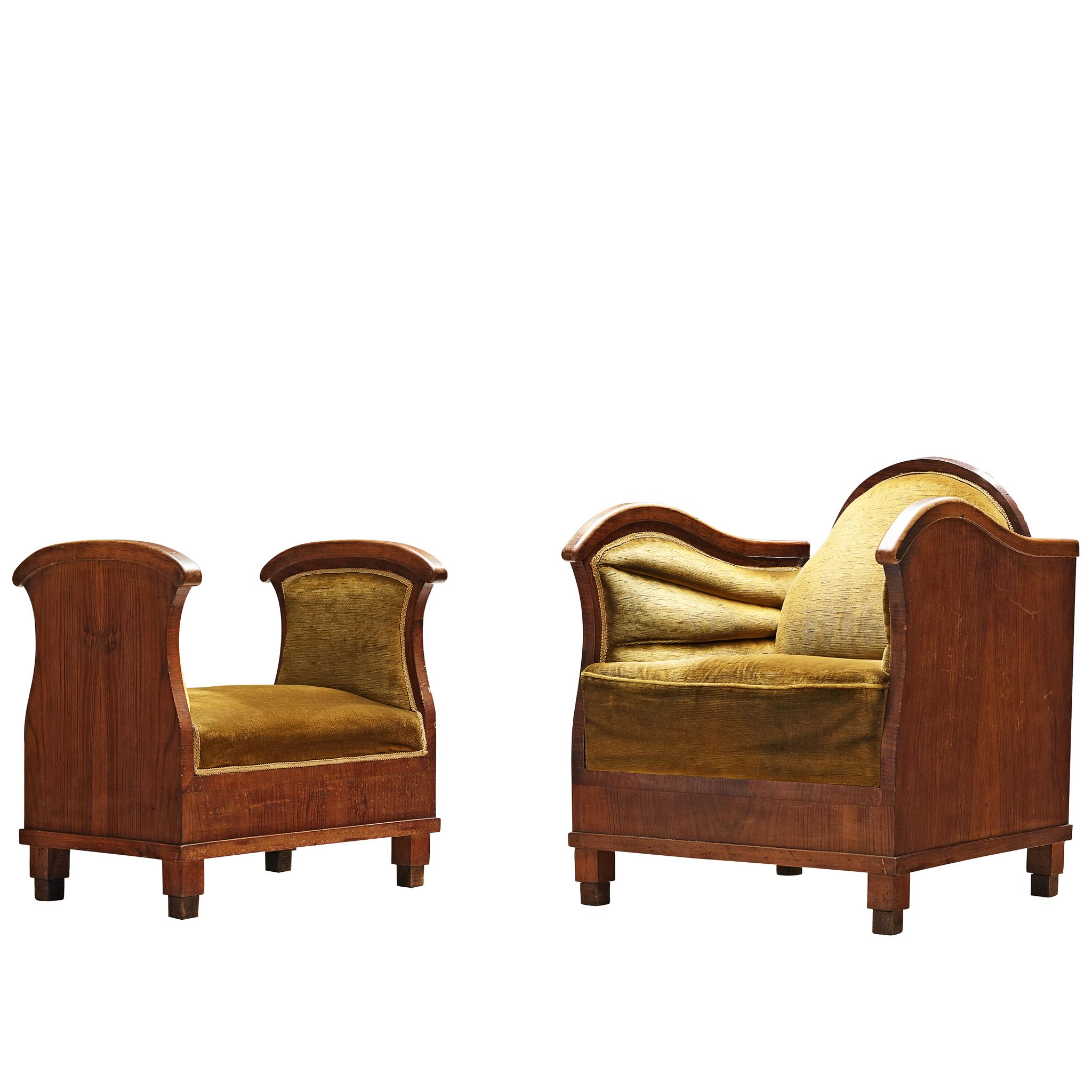 Art Deco lounge chairs in wood and moss green velour, Europe, 1930s. 

Set of two armchairs with accompanying ottomans upholstered in green velour. The comfortable chairs have a laidback backrest and wavy armrests, emphasized by the detailing in the