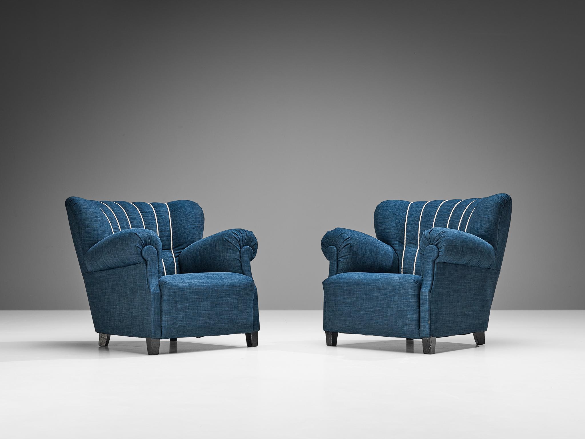 Pair of lounge chairs, wood and blue upholstery, Europe, 1940s

This fine pair of lounge chairs undoubtedly breathes the late art deco period of the 1940s. The design has a certain theatrical aesthetic with curved armrests flowing slightly outwards.