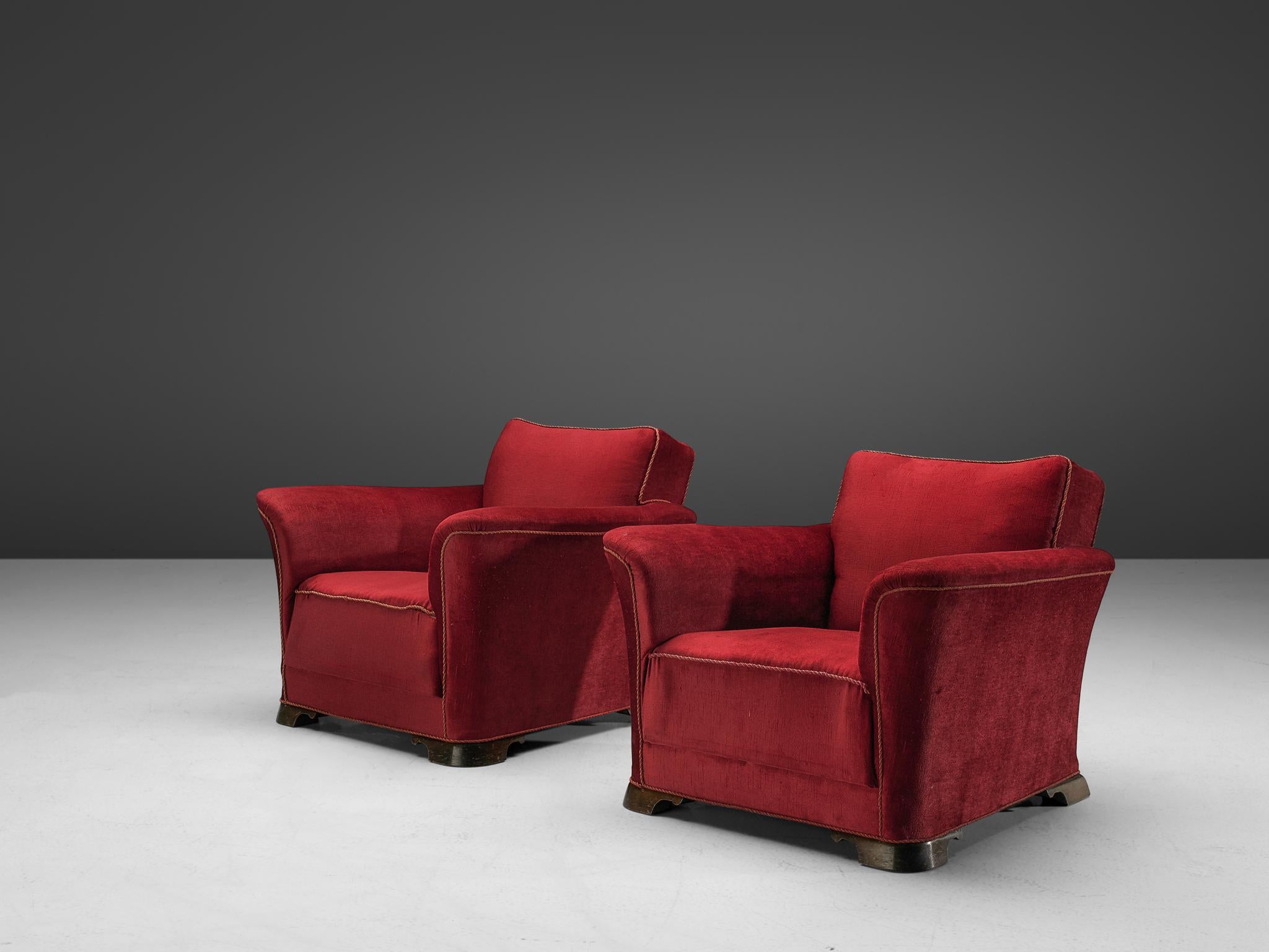Pair of lounge chairs, velours and mahogany, Denmark, 1940s

A set of two grand and comfortable armchairs in red velours upholstery. The lounge chair features a thick seat, which is characteristic for the Art Deco movement. Large upsweeping armrests
