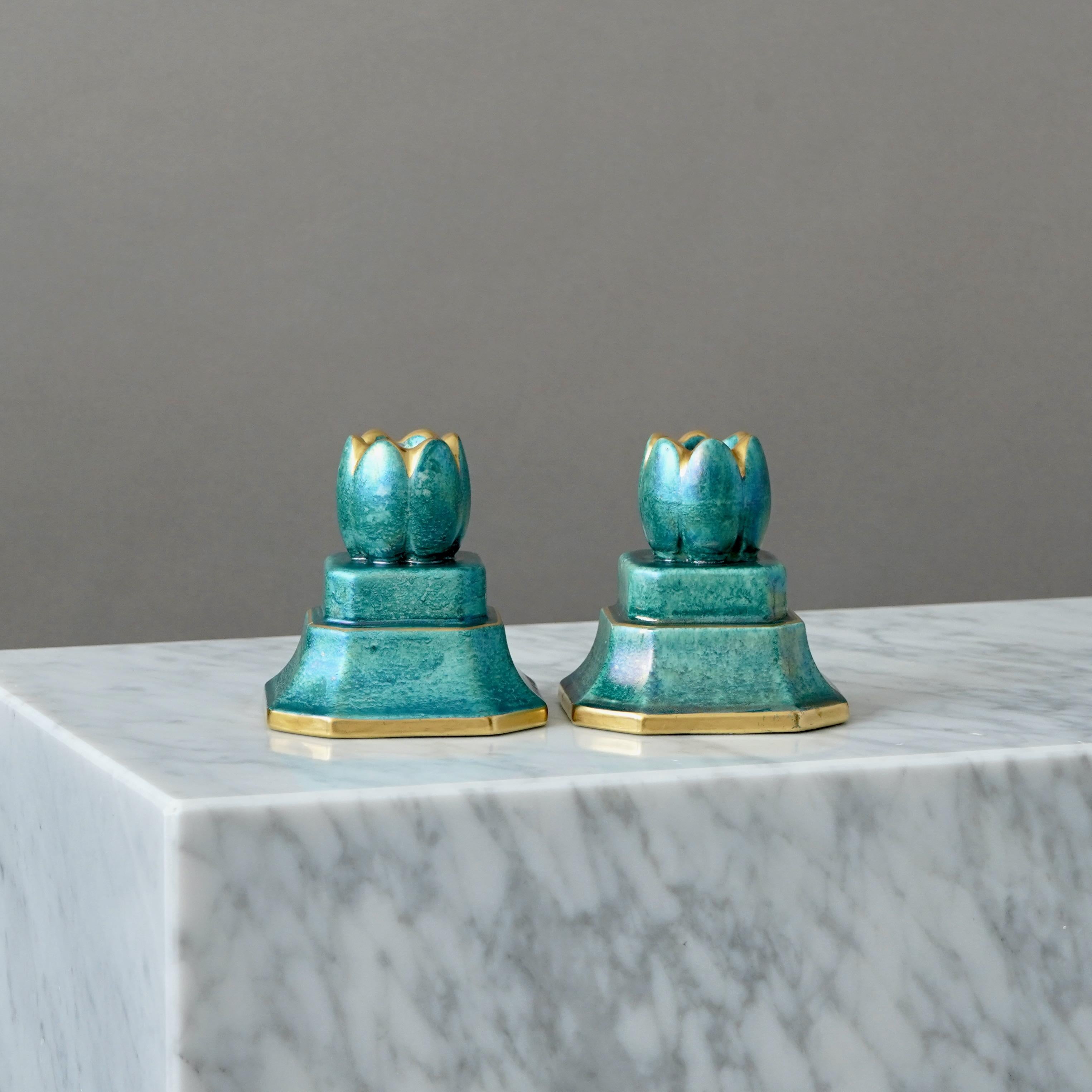 Una coppia di candelieri con un'incredibile smaltatura a lustro e dettagli dorati dipinti a mano. Grazia scandinava / Art Deco.
Realizzata da Josef Ekberg a Gustavsberg, Svezia, negli anni '1930.

Ottime condizioni, solo una leggera usura dell'oro.