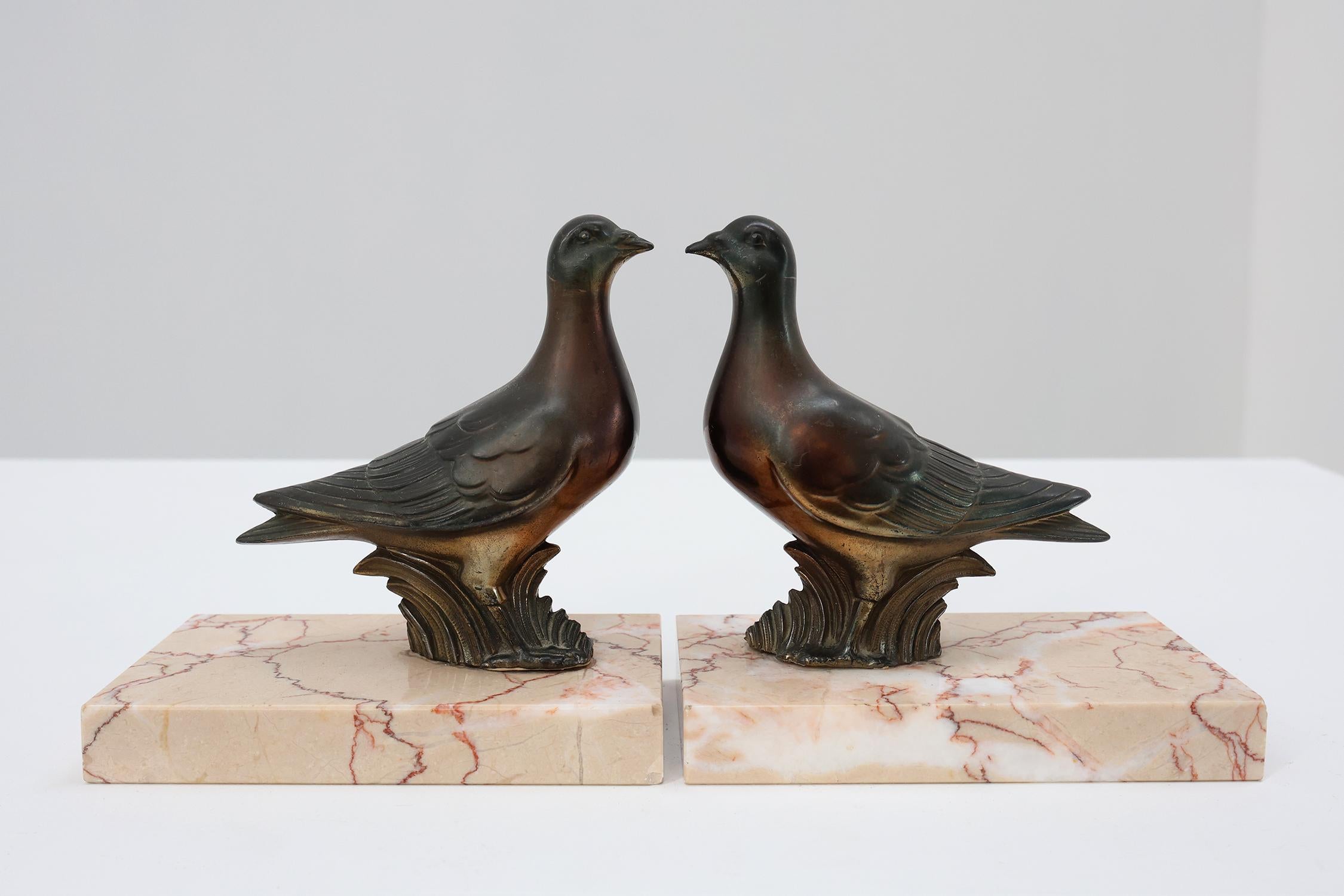 France / 1930 / bookends / marble, bronze / Art Deco

Nice pair of Art Deco style bronze dove bookends, crafted in France in the 1930s. These bookends feature two beautiful crafted bonze doves, each on a salmon colored marble base with red and white