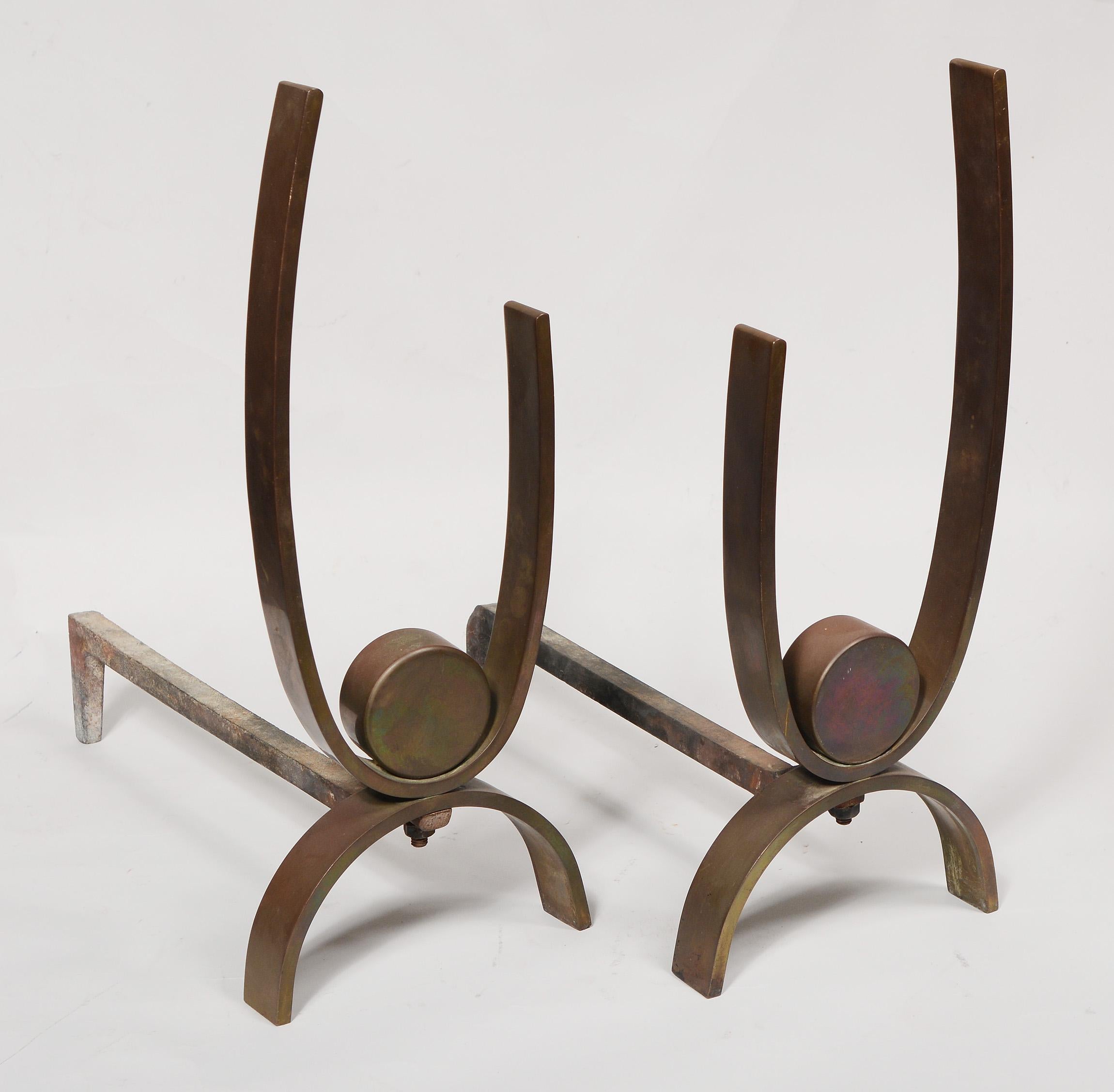 Modernist brass andirons reminiscent of Walter Von Nessen designs. These are the earlier version of this andiron with the disk being solid brass. Later the disk was hollowed out in the back. These have a patina that has developed over many years.