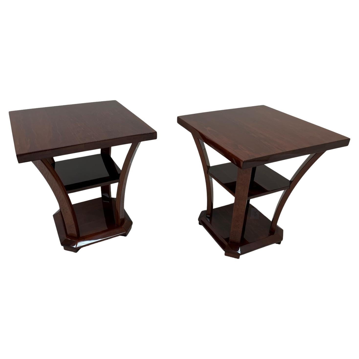 Elegant Art Deco side tables reminiscent of the works by Gilbert Rohde or Donald Deskey. A great pair of Machine Age Art Deco Tables. The tables feature three tiers connected by four curving streamline supports. A very versatile piece; perfect as an