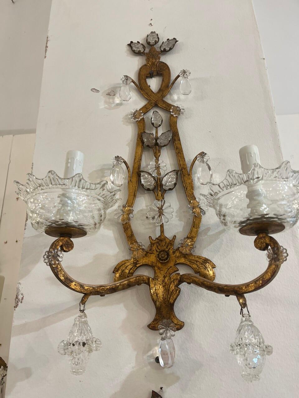 Illuminate your space with the glamour of the 1930's through this stunning pair of Art Deco Murano gilt wall sconces. Crafted with exquisite detail, their opulent design features intricate glasswork and lavish gilding, evoking the elegance of 1920s