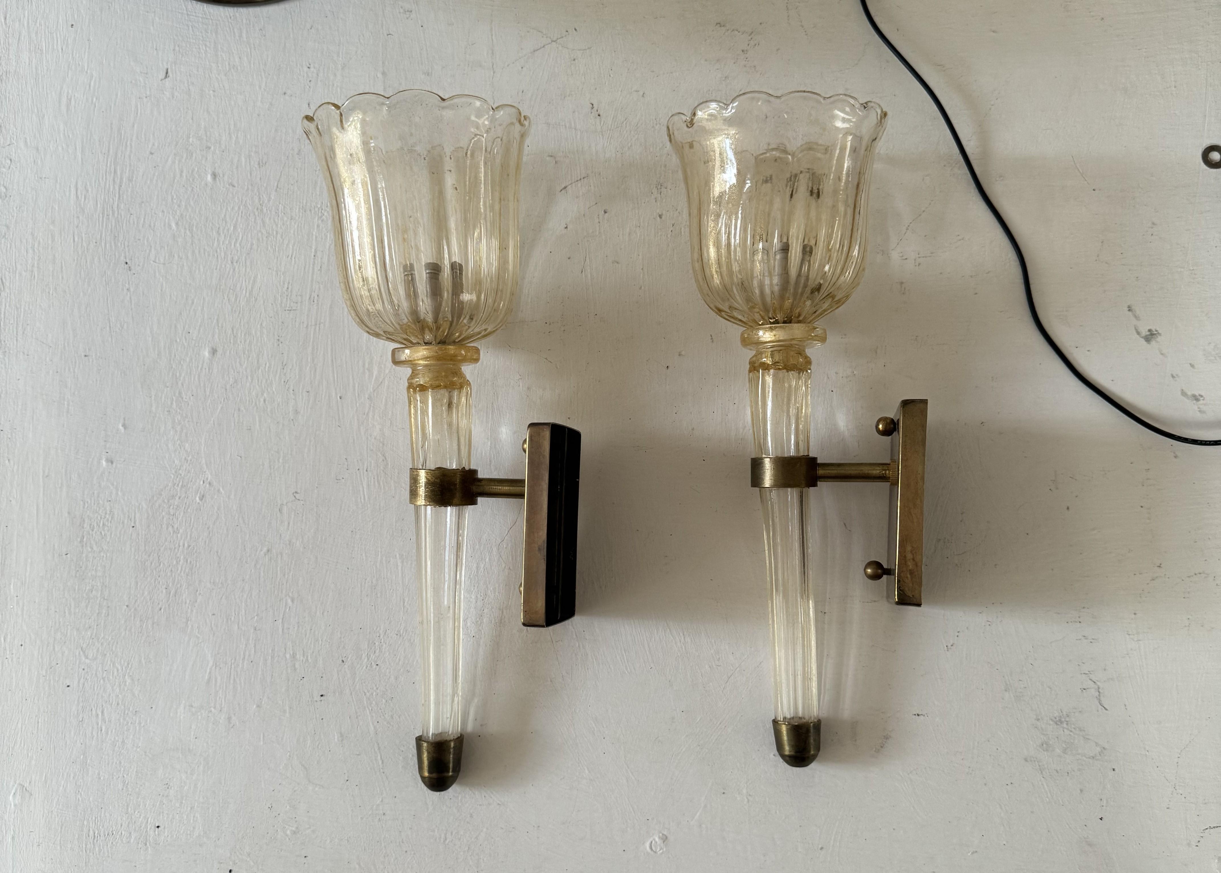 Hermoso par de apliques antiguos de cristal de Murano, cada uno fue hecho a mano en Murano, Italia, al estilo de la famosa fábrica Barovier e Toso hacia 1930.
Cada una está fabricada con herrajes de latón y cristal dorado incluido y admite una