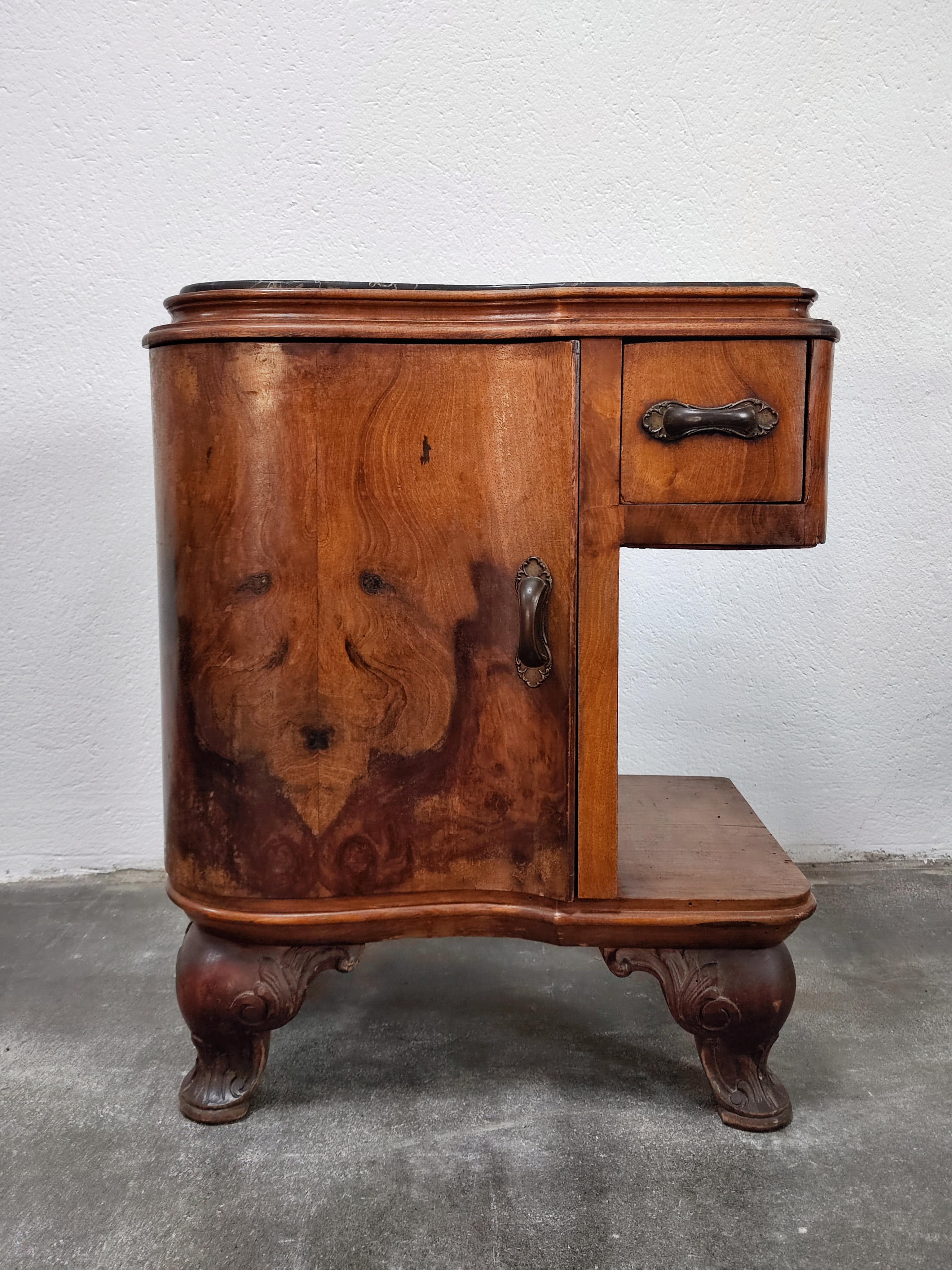 In this listing you will find a pair of lixurious antique nightstands. The nightstands belong to Art Deco period, inspired with modified venetian baroque, with their feet done by machine driven tool. They feature curved doors and are done in walnut
