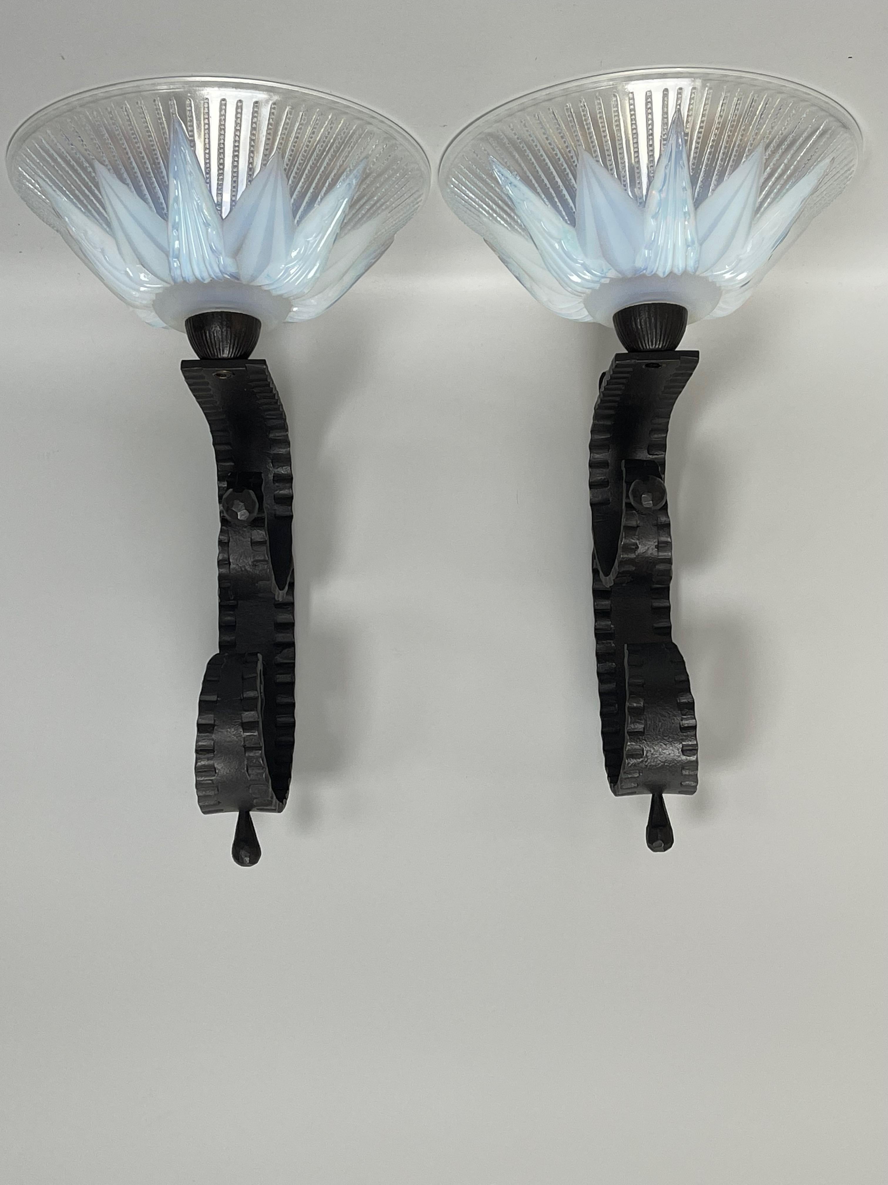 Pair of wall lights around 1930.
Hammered wrought iron and opalescent molded glass with geometric decoration by Ezan (unsigned).
These wall lights are electrified and in perfect condition.

Measures: Total height: 34 cm 13.38 in
Width: 20.5 cm