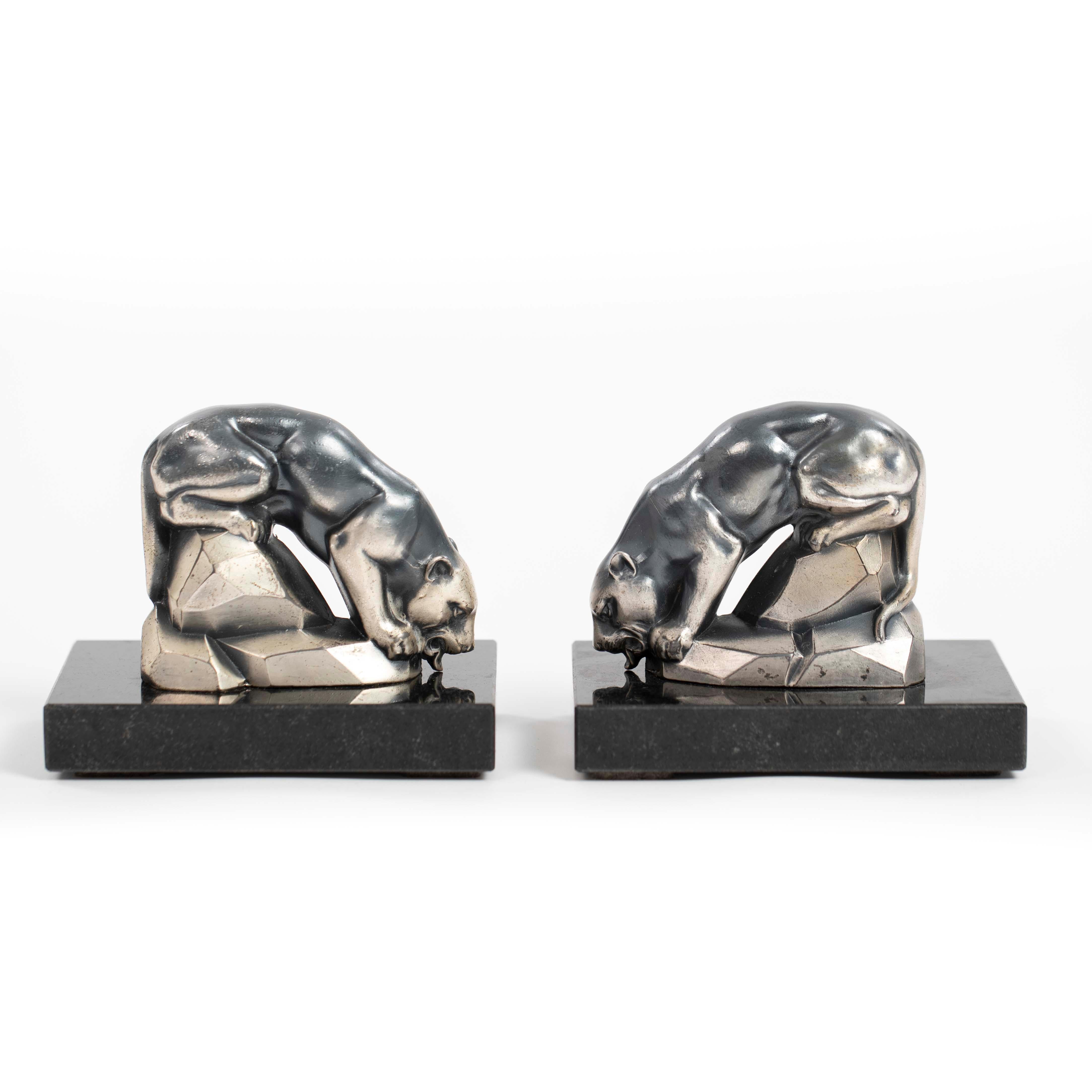 Coppia di reggilibri Art Déco a forma di pantera in bronzo fuso nero-argento su una base di marmo nero di Maurice Font.

Gli animali sono raffigurati seduti su blocchi di pietra cubici mentre bevono.
Il design è molto raffinato, con una sfumatura di