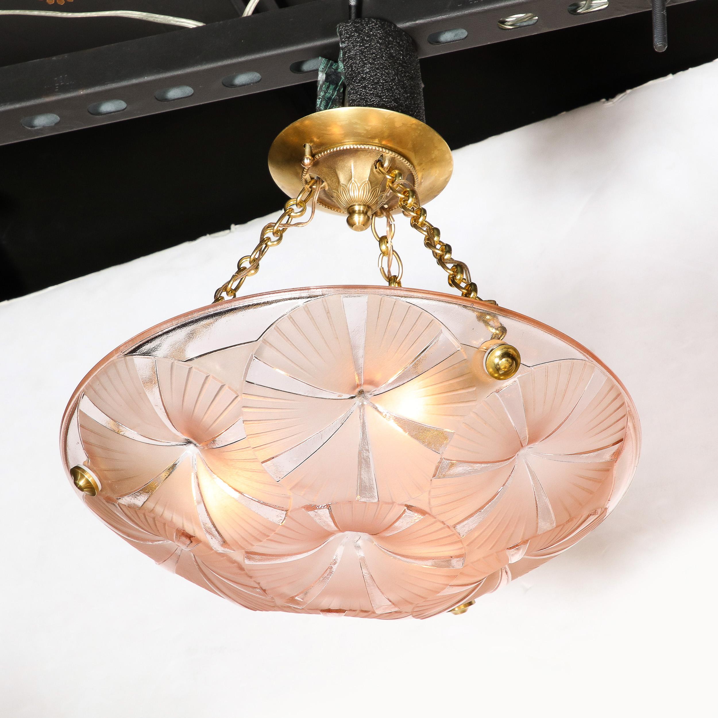 This alluring and materially exquisite Pair of Art Deco Pendant Chandeliers in Molded & Frosted Rose Glass are signed Degue and they originate from France, Circa 1930. Featuring a single rose hued molded glass shade with abstracted circular