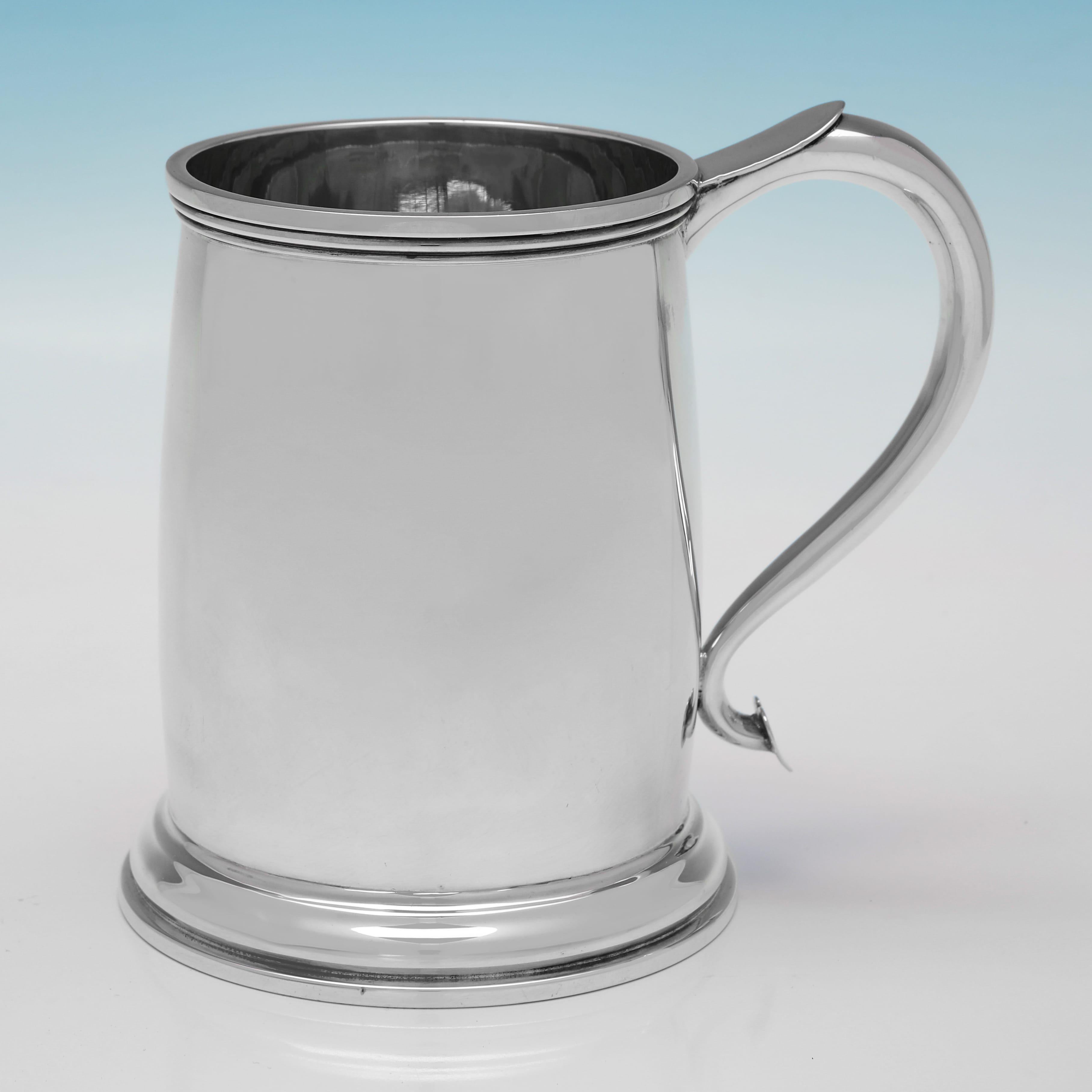 Marcadas en Sheffield en 1935 por Atkin Brothers, este elegante par de tazas de plata de ley de la época de Jorge V son de diseño sencillo, con bordes de caña y bases escalonadas. Cada taza mide 13,5 cm de altura, 14,5 cm de asa a asa y 10 cm de