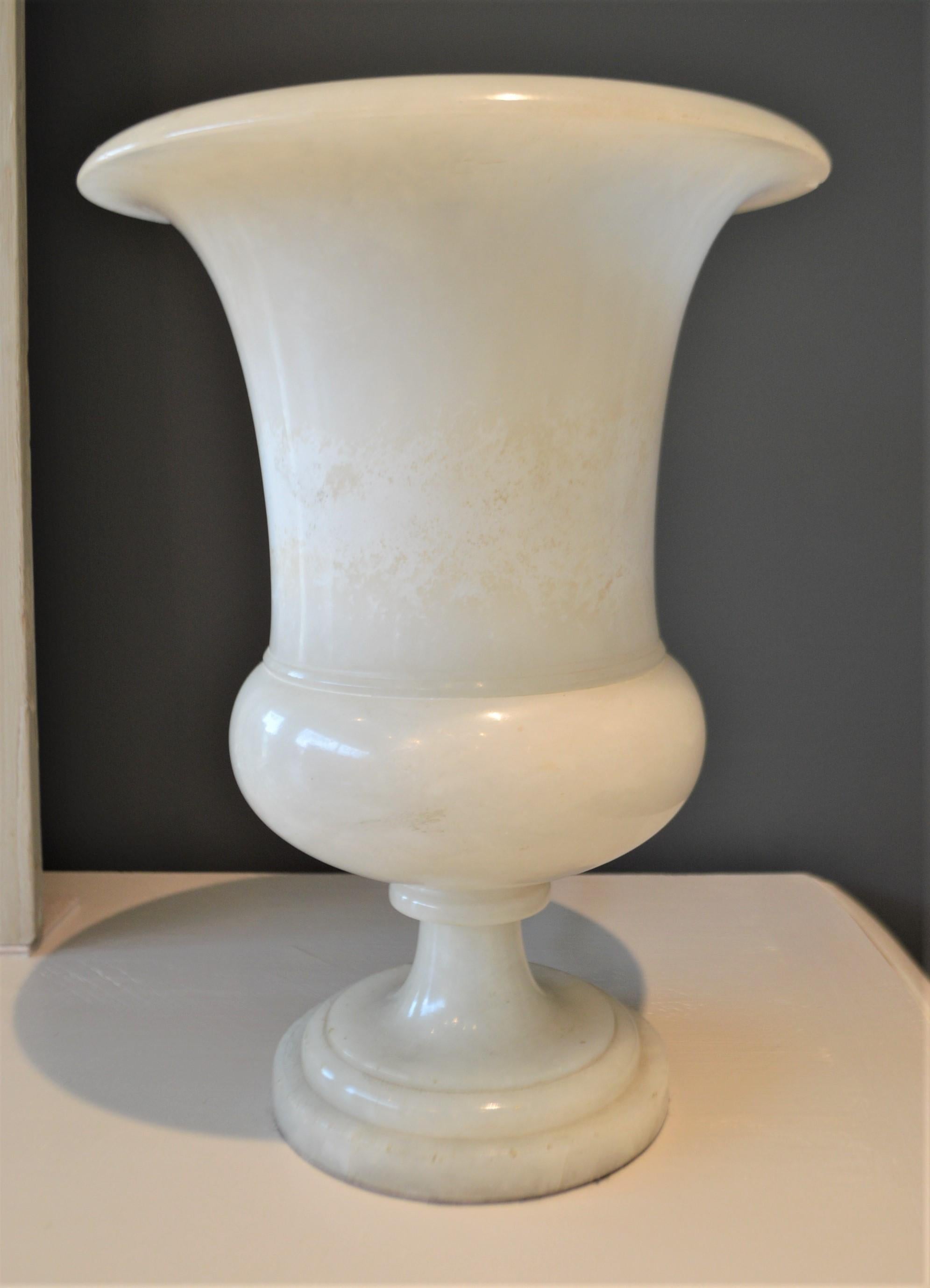 Art Deco period white marble urns that have been converted into nice
table lamps. Attractive and decorative without the light and brings much drama when lit at night. The color of the marble changes where the light hits when turned on. Each urn has