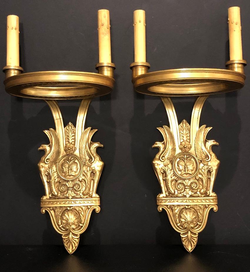 Pair of signed gilt bronze wall sconces by Sterling Bronze Co., New York. Beautiful casting in gilt bronze from the Art Deco period decorated with elements from the Roman Empire.