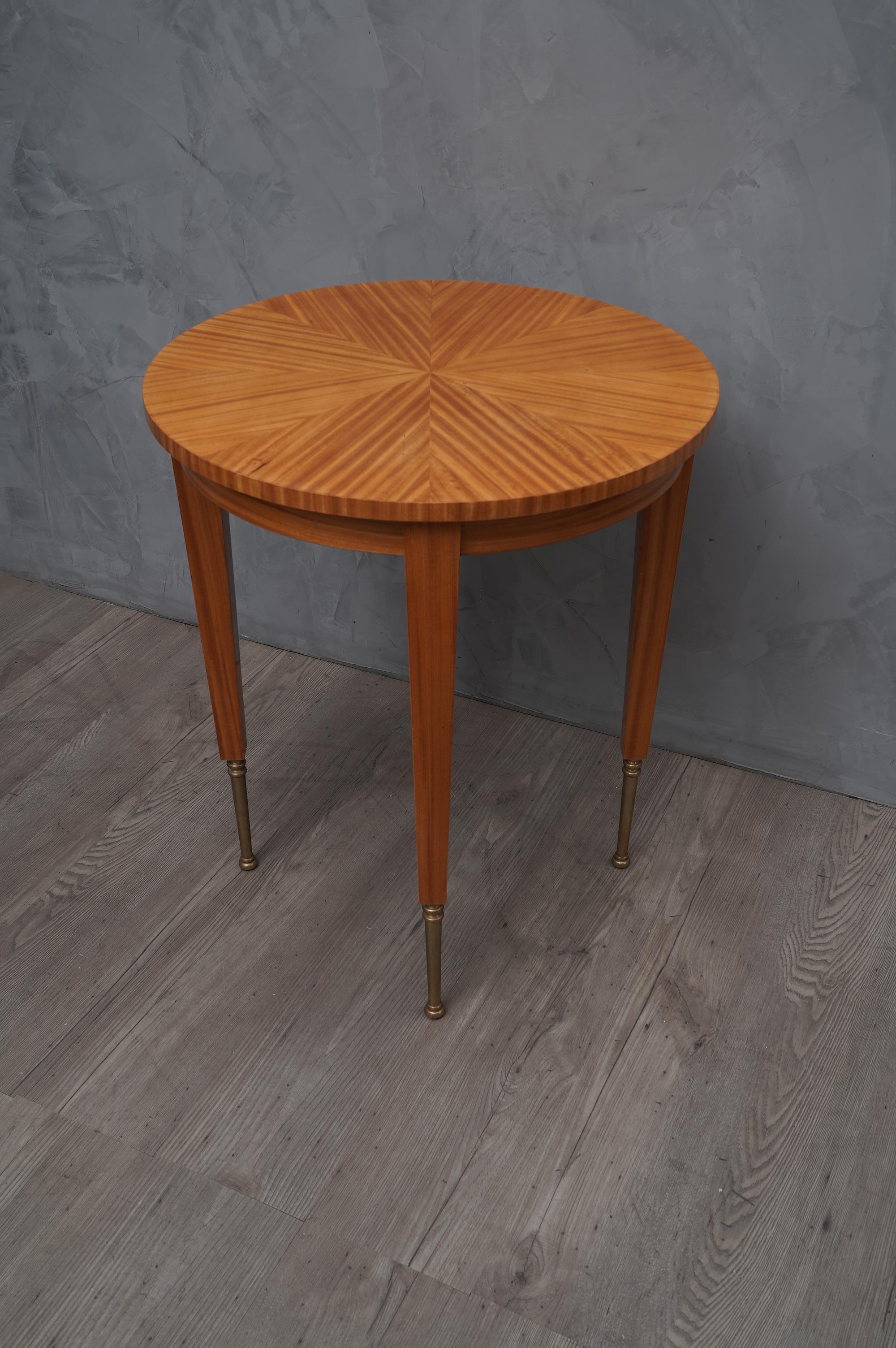 Very elegant appearance, and velvety veneer, for a couple of refined art deco side tables.

All veneered in satinwood. Of round shape, with four spiked legs, its foot is made of brass. Under the top there is a band that runs all around, here are