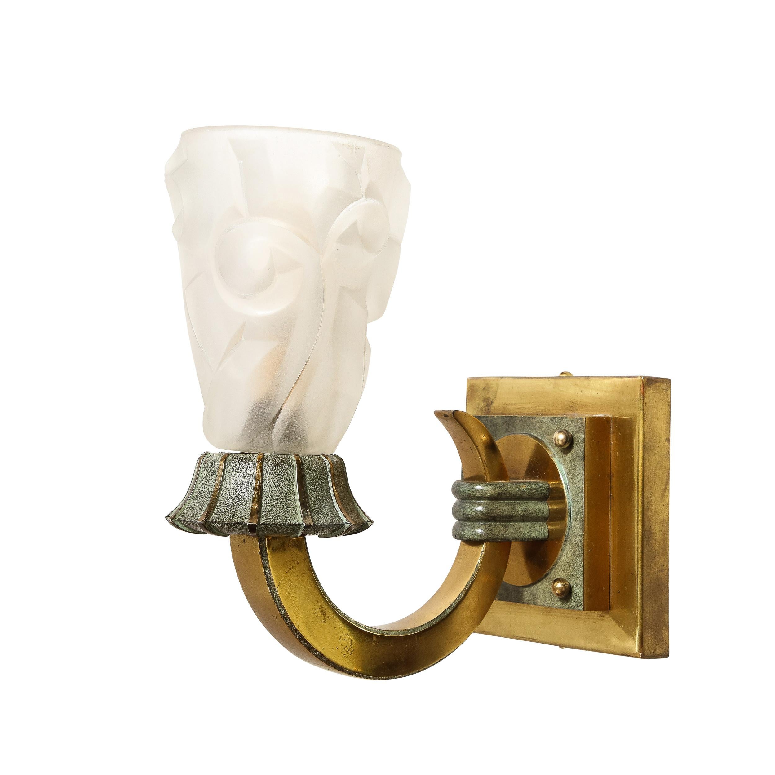 This uniquely charming pair of Art Deco Sconces in Polished Brass with Frosted Glass Shades is created by the company Degué, originating from France, Circa 1930. Featuring elegant curvatures and cubic sensibility, the sconces are framed in polished