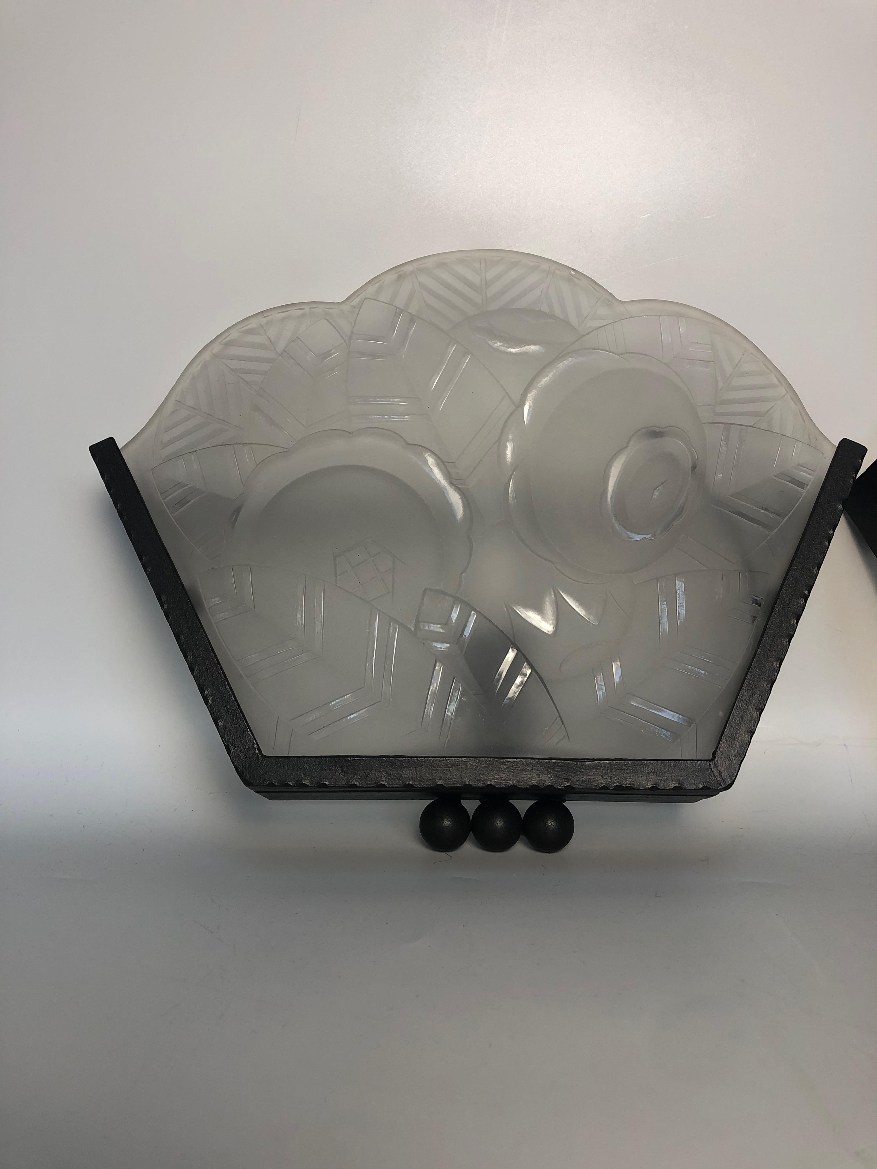 Pair of art deco wall lights circa 1930 with hammered iron frame.
  Molded glass plates decorated with stylized flowers and banana leaves.
Electrified, E14 socket and screw bulb.

Width: 30.5cm
Height: 23.5cm
Depth: 7cm
Weight: 5 Kg