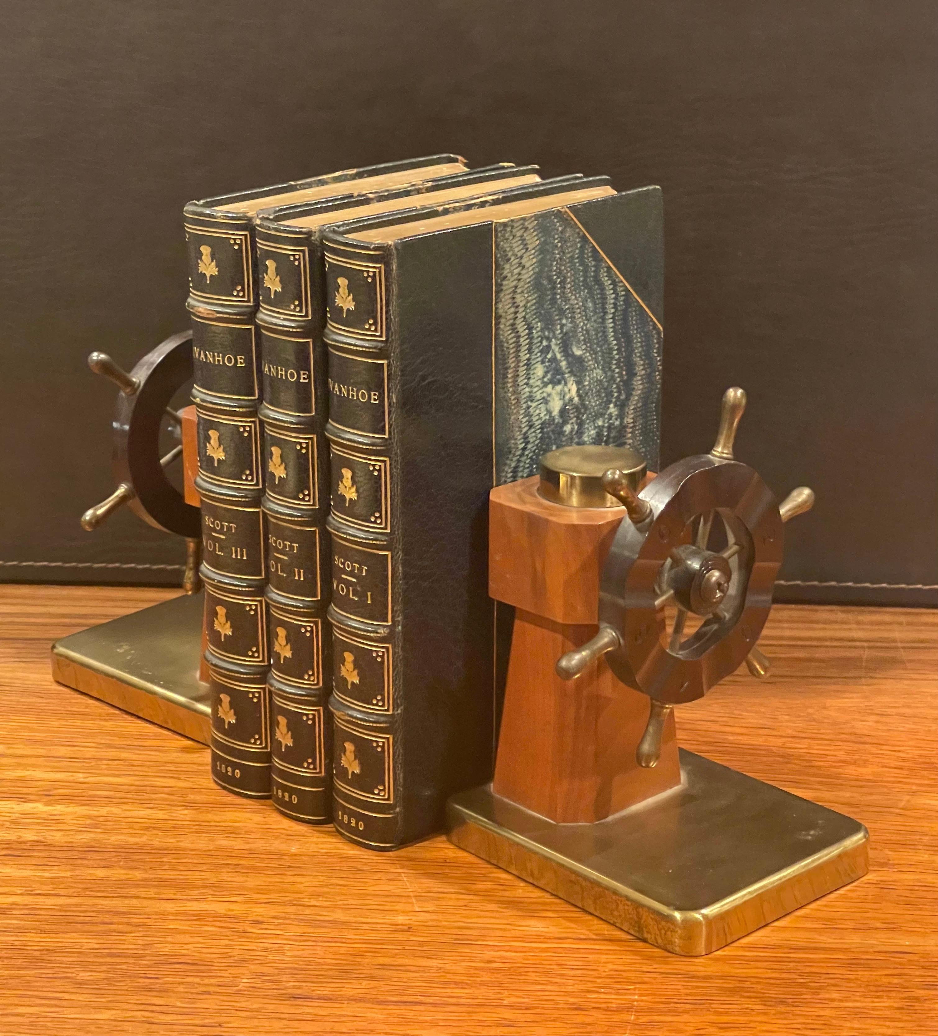 A very nice pair of Art Deco ship's wheel bookends by Walter Von Nessen for Chase & Co., circa 1930s. The bookends are made of walnut, brass and bakelite; they depict the captain’s wheel of a ship. The base, spokes, and wheel handles are solid