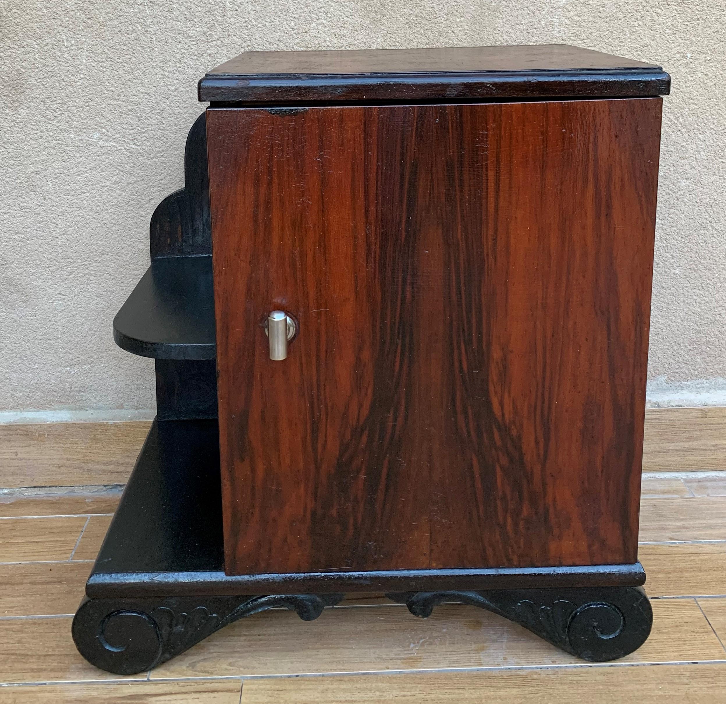 This pair of circa 1930s French Art Deco side cabinets could be used to flank a sofa or as nightstands. Each has a storage compartment with hinged door and narrow open shelves at the sides. Cabinets are set on ebonized trestle foot at the front.