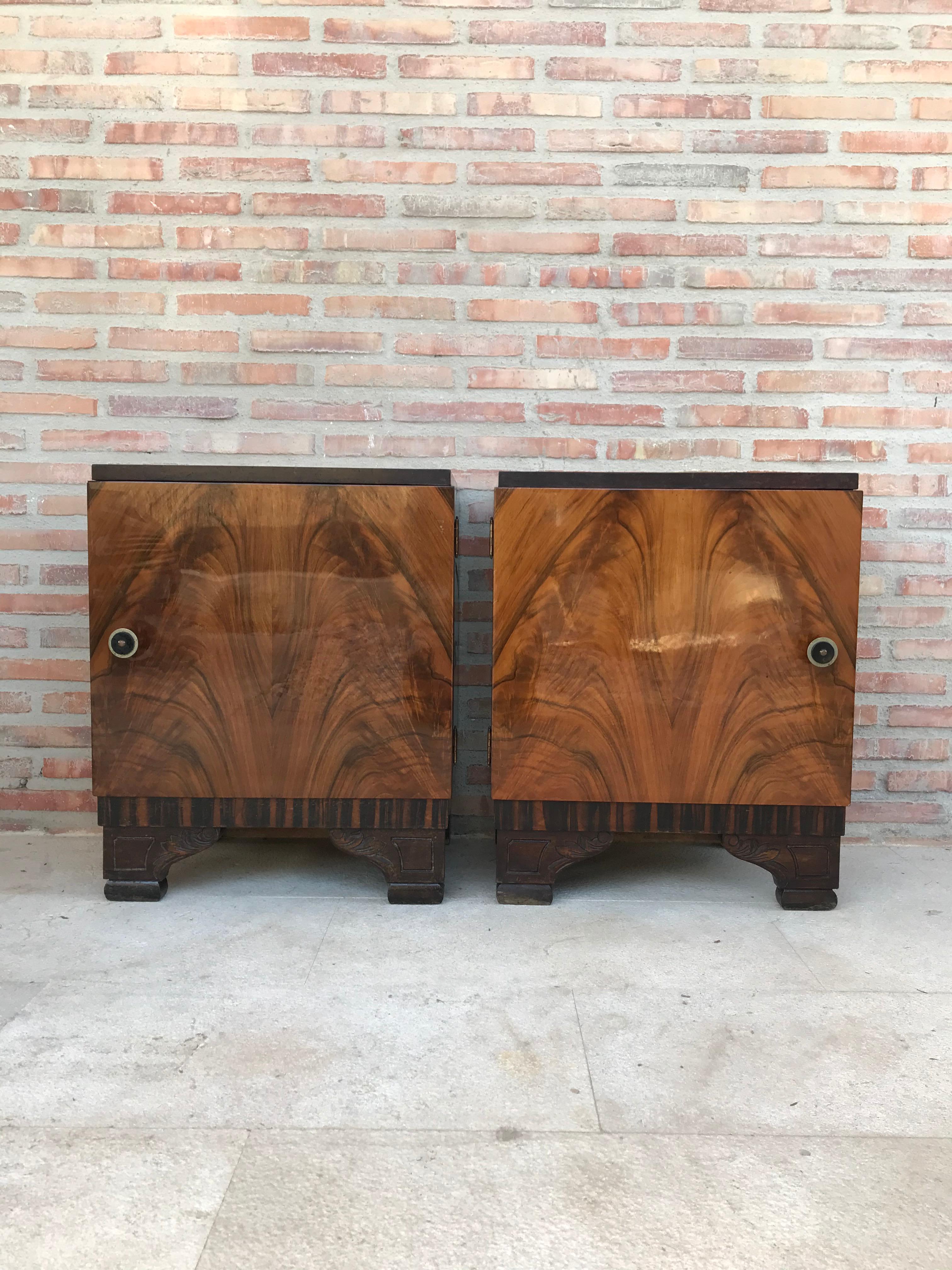 This pair of circa 1930s French Art Deco side cabinets could be used to flank a sofa or as nightstands. Each has a storage compartment with hinged door and narrow open shelves at the sides. One-drawer and one box. Cabinets are set on ebonized