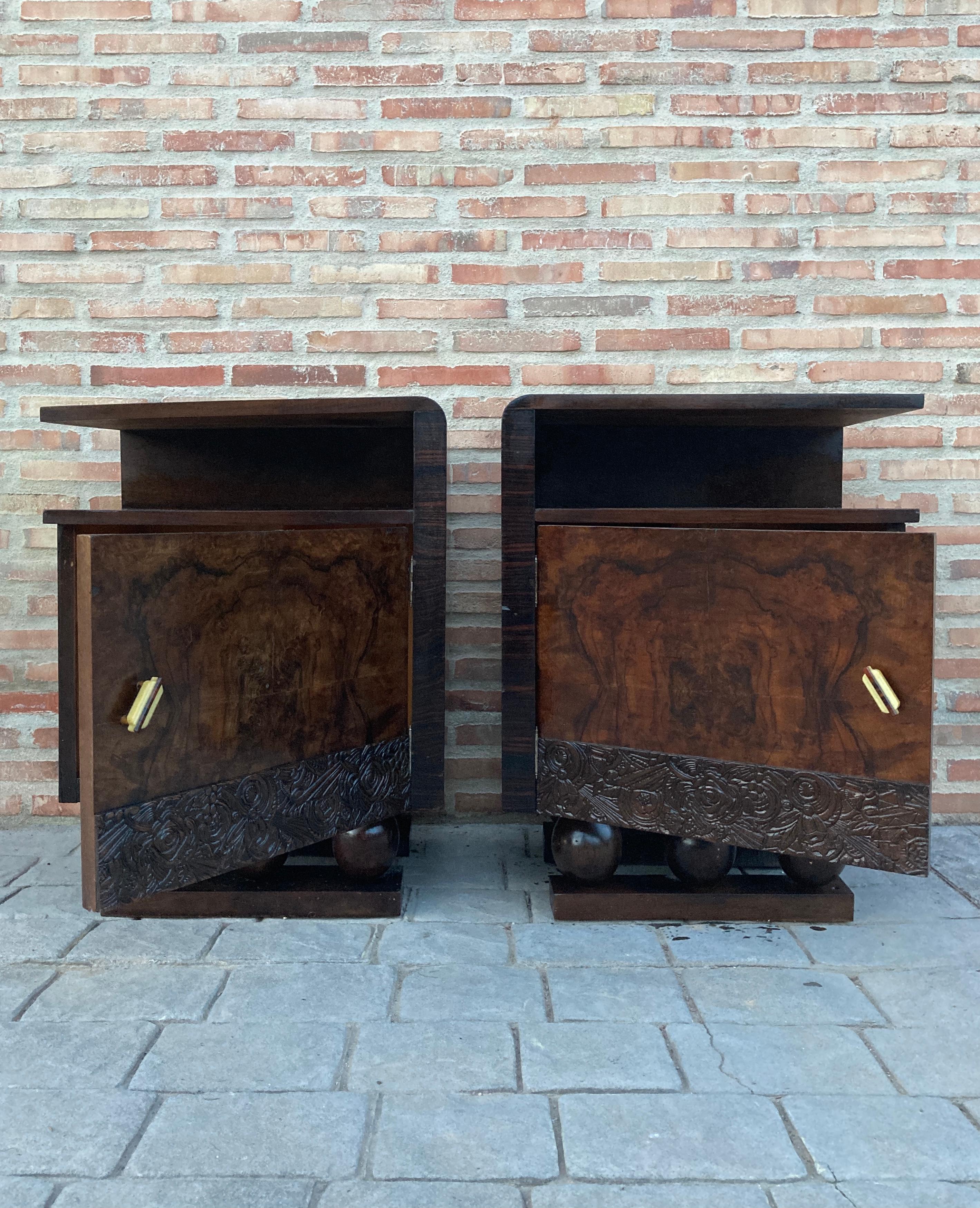 This pair of circa 1930s French Art Deco side cabinets could be used to flank a sofa or as nightstands. Each has a storage compartment with hinged door and narrow open shelves at the sides. One-drawer and one box. Cabinets are set on ebonized