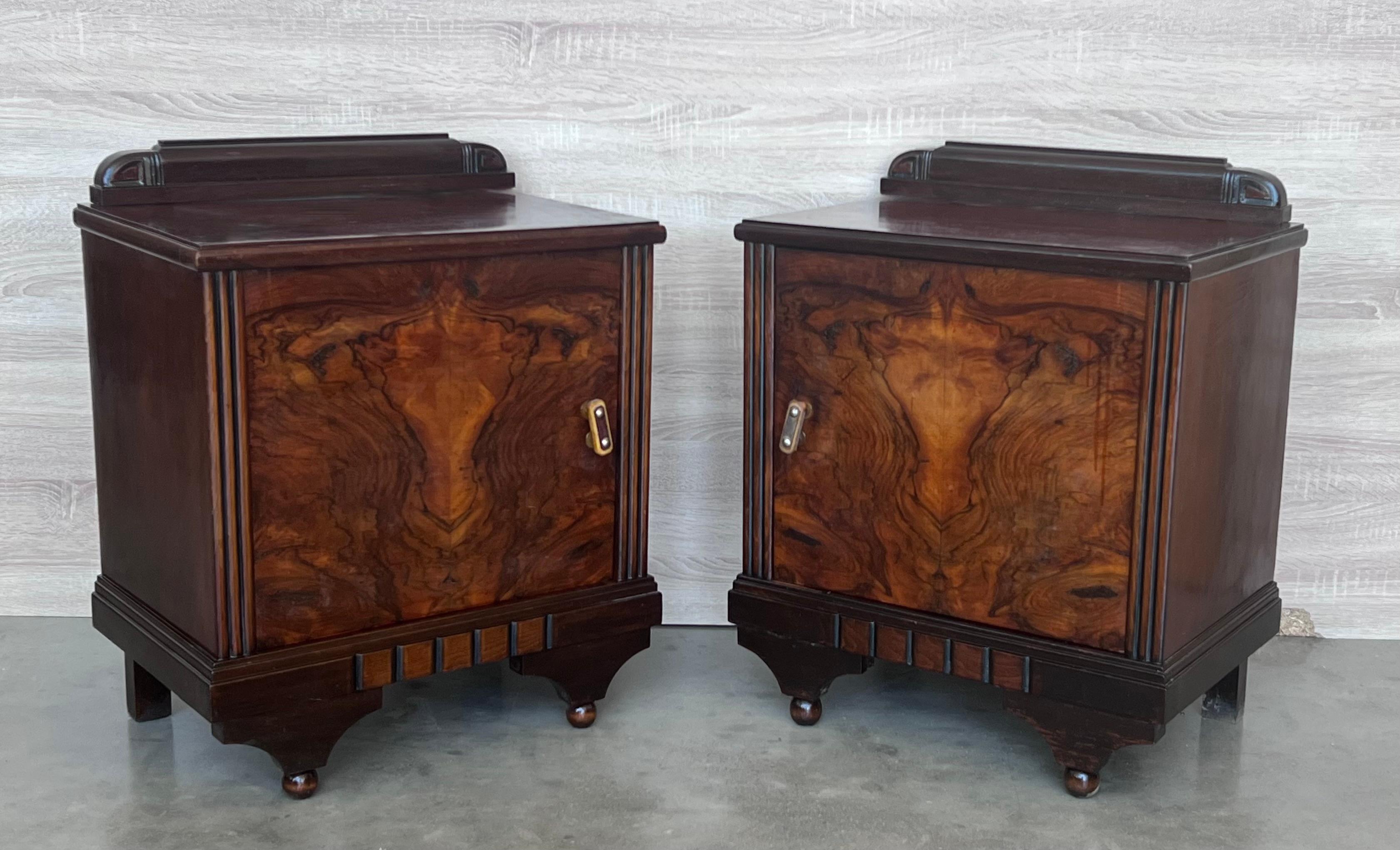 This pair of circa 1930s French Art Deco side cabinets could be used to flank a sofa or as nightstands. Each has a storage compartment and one interior drawer and one ceramic box. Cabinets are set on ebonized trestle foot at the front.
 
Height to