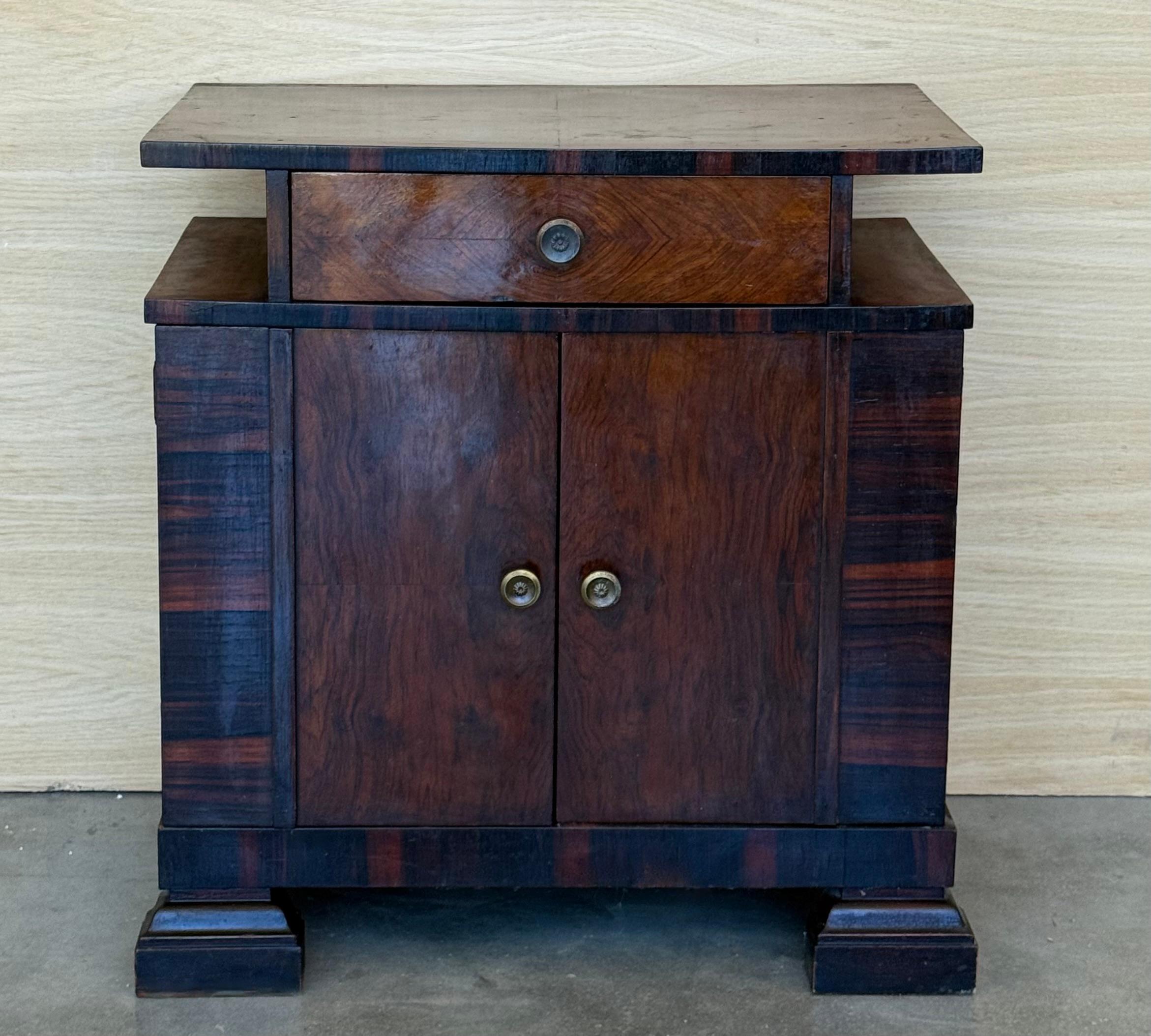 Questa coppia di credenze francesi Art Déco degli anni '30 circa può essere utilizzata per affiancare un divano o come comodino. Ognuno di essi ha un vano portaoggetti con porta a battente e stretti ripiani aperti ai lati. Un cassetto e una scatola.