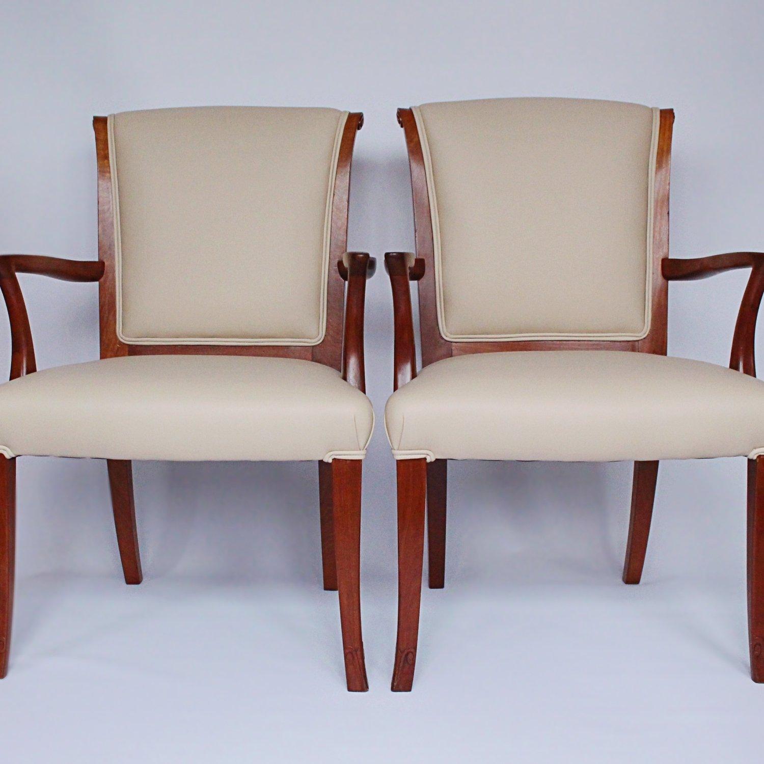 A pair of French Art Deco side chairs with walnut frames. Scrolled and carved detail to frames. Upholstered in cream leather. 



  