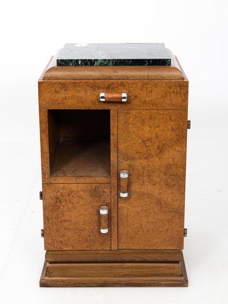 Pair of Art Deco style side table with original green marble tops, circa 1930s. Each table features two cabinets, one cubbyhole shelf, and a single top drawer. Please note of wear consistent with age.