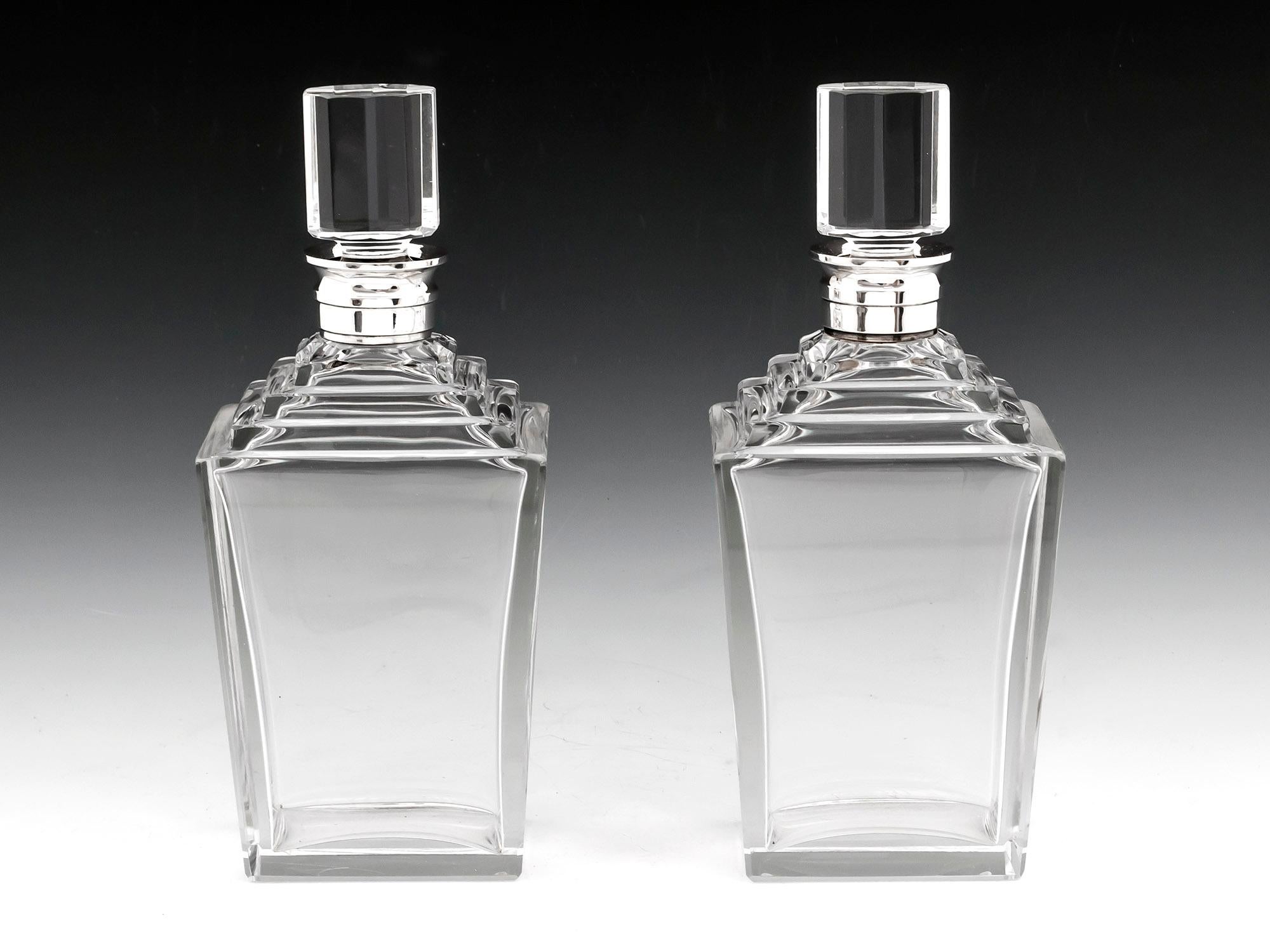 Pair of exquisite Art Deco Decanters with tapered sides, stepped shoulders and with sterling silver collars by Birmingham Silversmiths “Adie Brothers Ltd”. Dated 1938. 

These fabulous decanters are typical of the luxurious decadent Art Deco