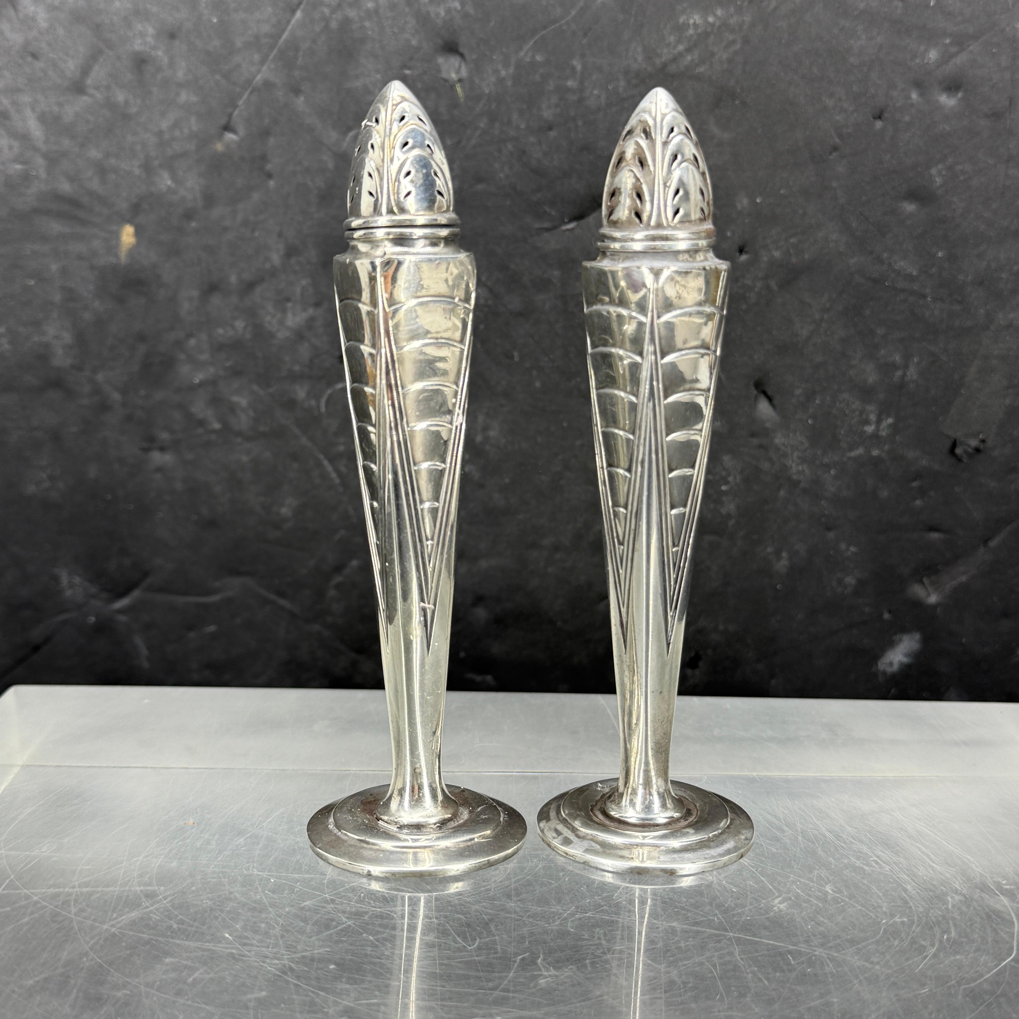 Set of salt & pepper shakers in polished silver plate. This classic English pair of salt and pepper dispensers are marked on the bottom. Wonderful addition to add to your table for everyday use or when entertaining. 
Marked International Sterling