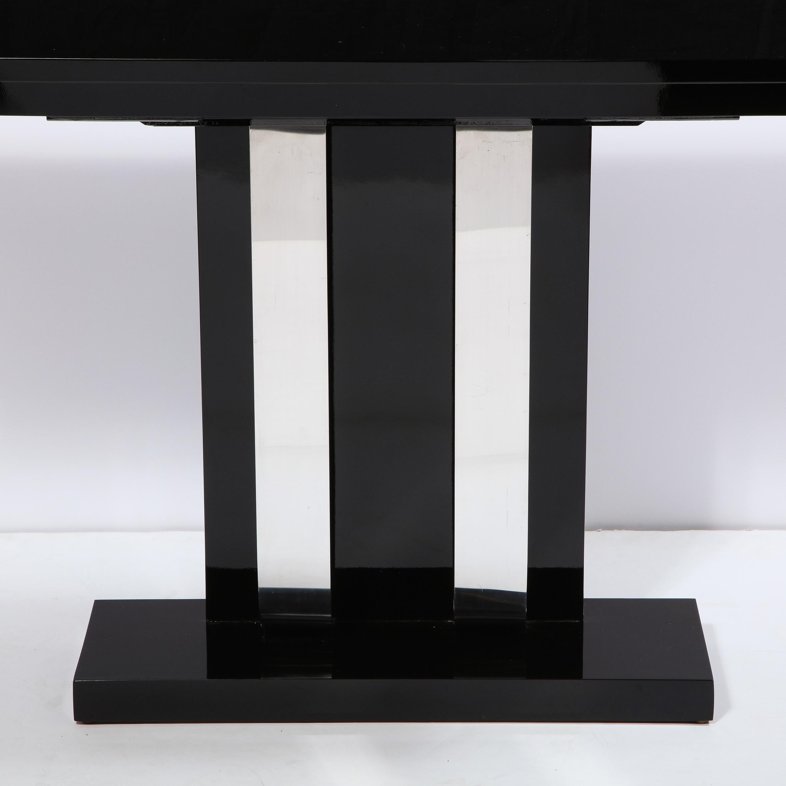 This elegant and graphic pair of Art Deco Machine Age console tables were realized in the United States, circa 1935. They feature rectilinear bodies with tiered skyscraper style tops and streamlined embellishments connecting the bases to the tops in