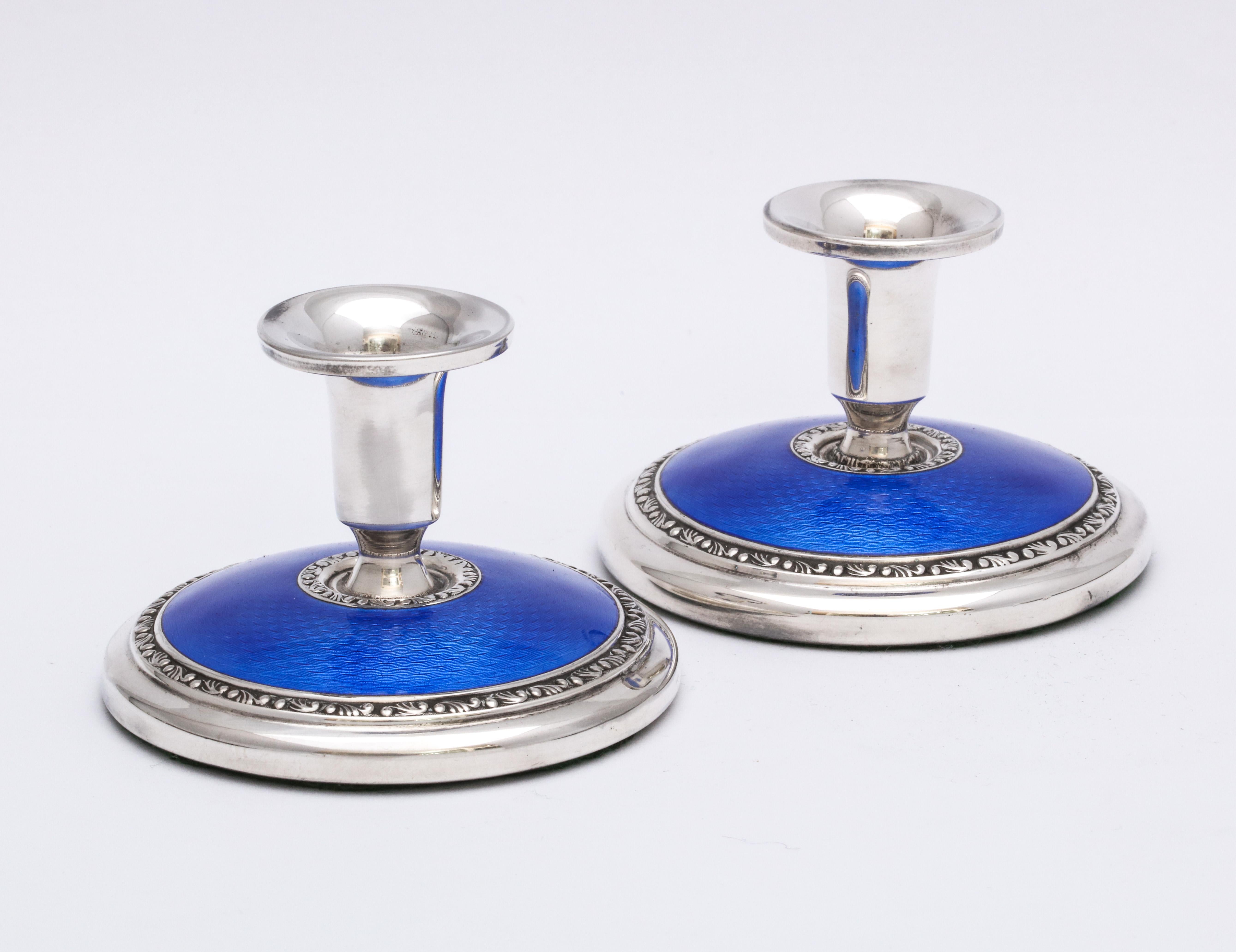 Pair of Art Deco, sterling silver and deep blue guilloche enamel candlesticks, Norway, circa 1930s, Norsk Solwaaren Industri - Makers. Each measures 2 inches high x 2 3/4 inches in diameter. Underside is covered in dark green felt. Weighted. Dark