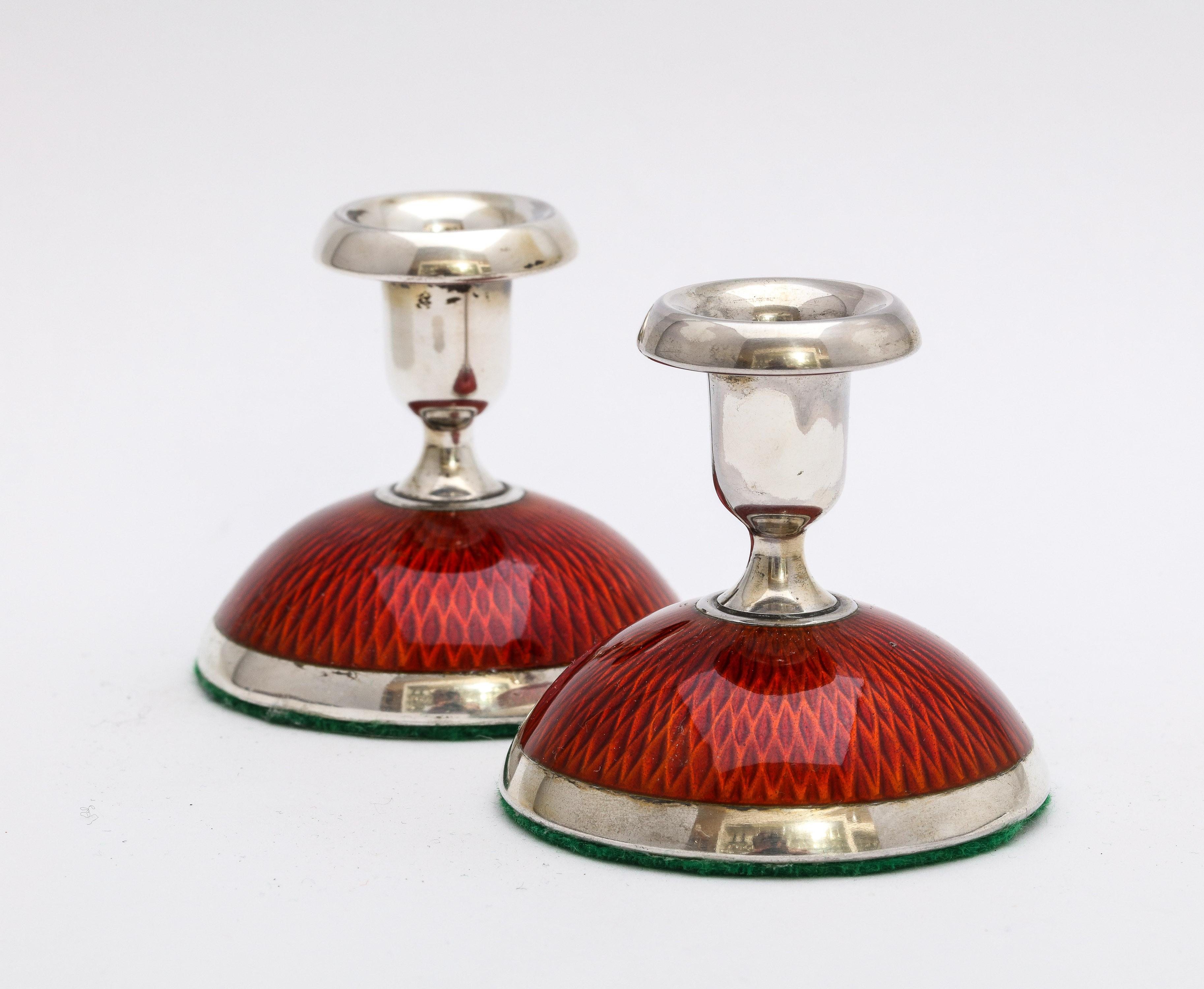 Pair of Art Deco, sterling silver and deep reddish-orange guilloche enamel candlesticks, Oslo, Norway, Ca. 1930's, Norsk Silvvareindustri - makers. Each candlestick stands 2 inches high x 2 inches diameter across its base. Each candlestick base is