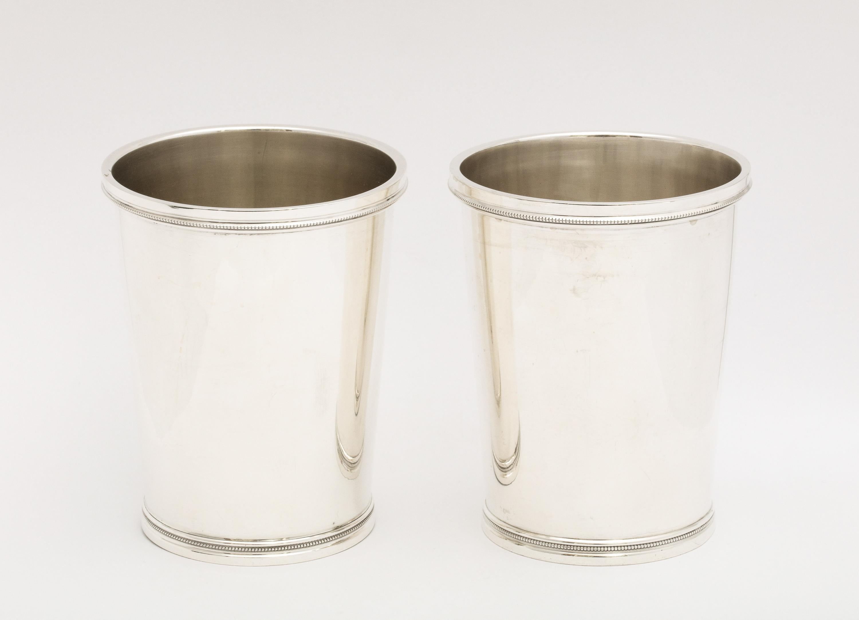 Pair of Art Deco, sterling silver mint julep cups, The Chicago Silver Company, Chicago, Illinois, Ca. 1930's. Each cup measures 4 inches high x 3 inches diameter. Combined weight of both cups is 8.575 troy ounces. Each cup is designed with a row of