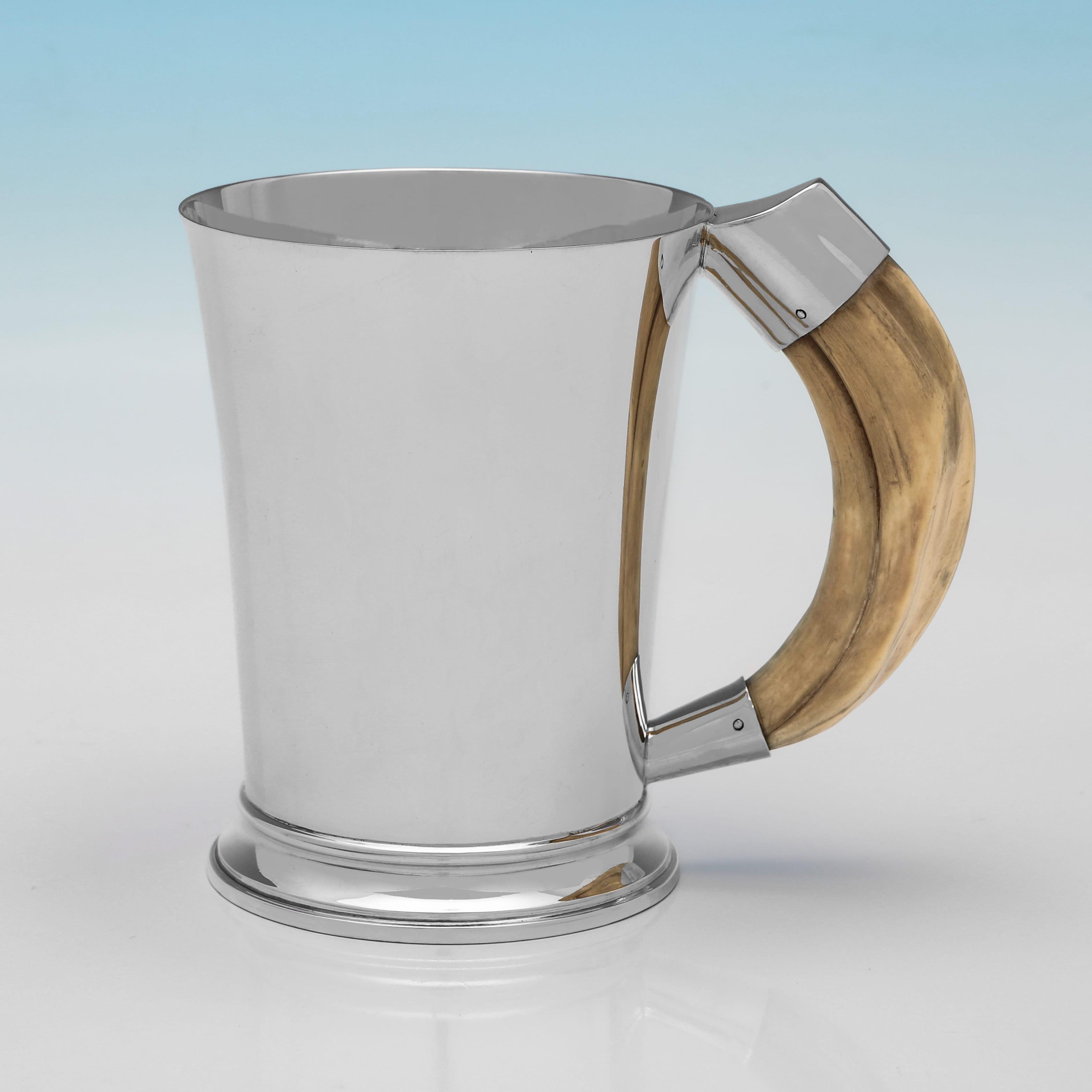 Con marchio a Londra nel 1937 da Goldsmiths & Silversmiths Co., questa elegante coppia di tazze in argento sterling del periodo di George VI presenta manici a forma di zanna di cinghiale e sono di gusto art déco. Ogni tazza misura 4,75
