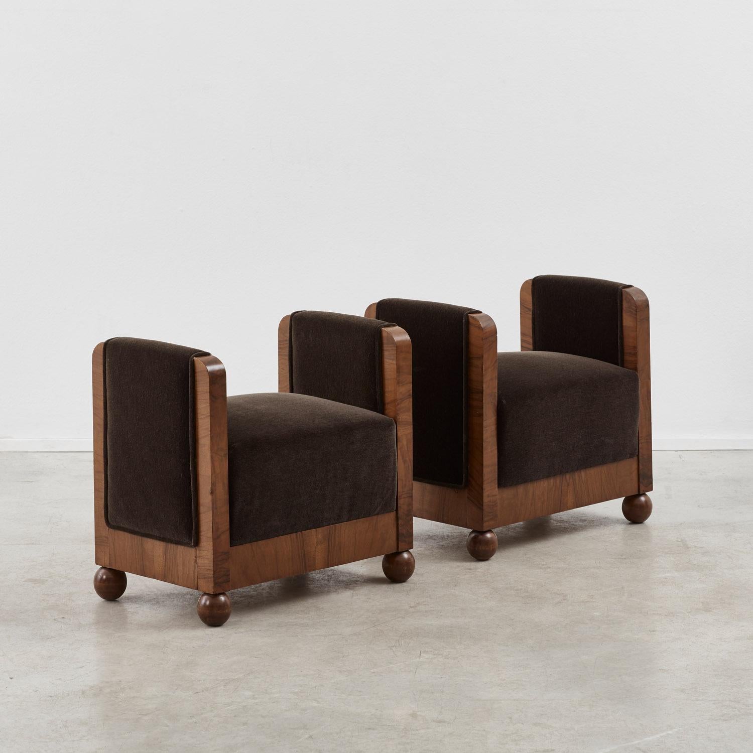 A happy sense of symmetry defines this pair of newly upholstered Italian Art Deco stools. Solid geometric volumes — almost architectural in presence — feature flanked sides that rise to equal height, forming a strong U-shaped silhouette.

The crisp