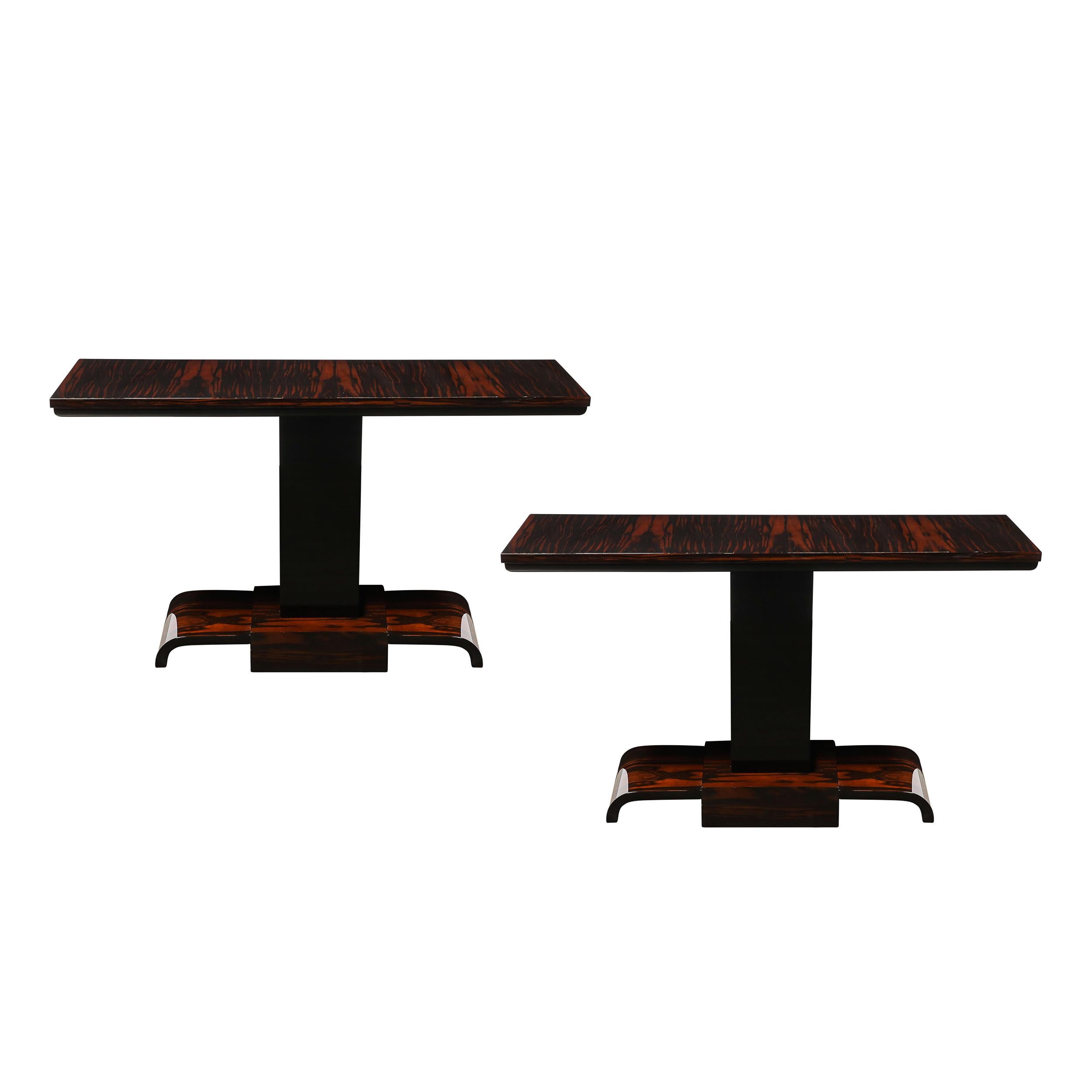 This exquisite pair of Art Deco console tables, crafted in France around 1935, exemplifies the streamlined elegance characteristic of the period. The tables are expertly fashioned from luxurious book matched zebra wood, featuring striking natural