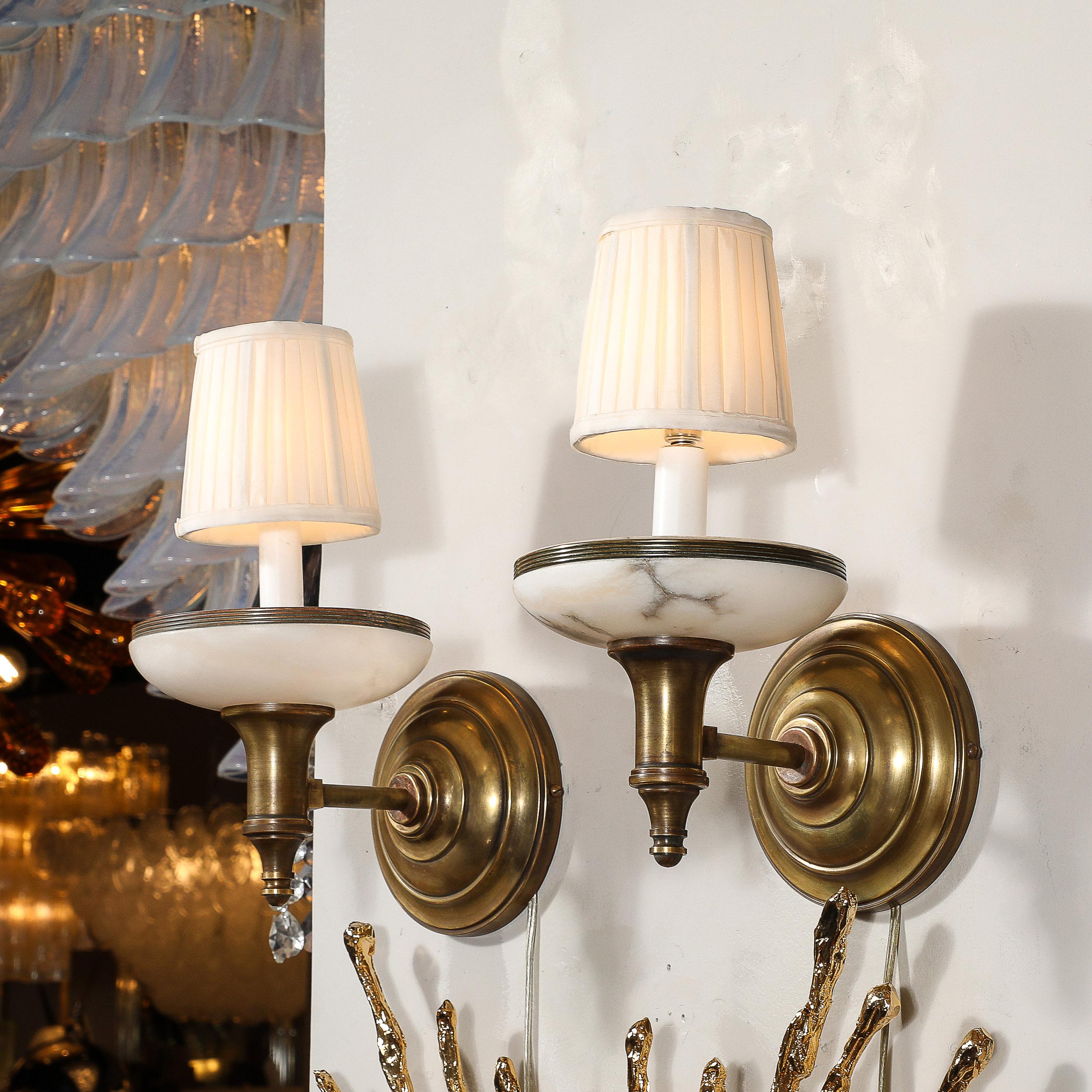 Cette charmante paire d'appliques en albâtre et laiton antique de style Art déco provient d'Italie au cours du 20e siècle. Ils présentent des abat-jours composés d'albâtre sculpté avec d'excellents détails veinés illuminés par la lumière des