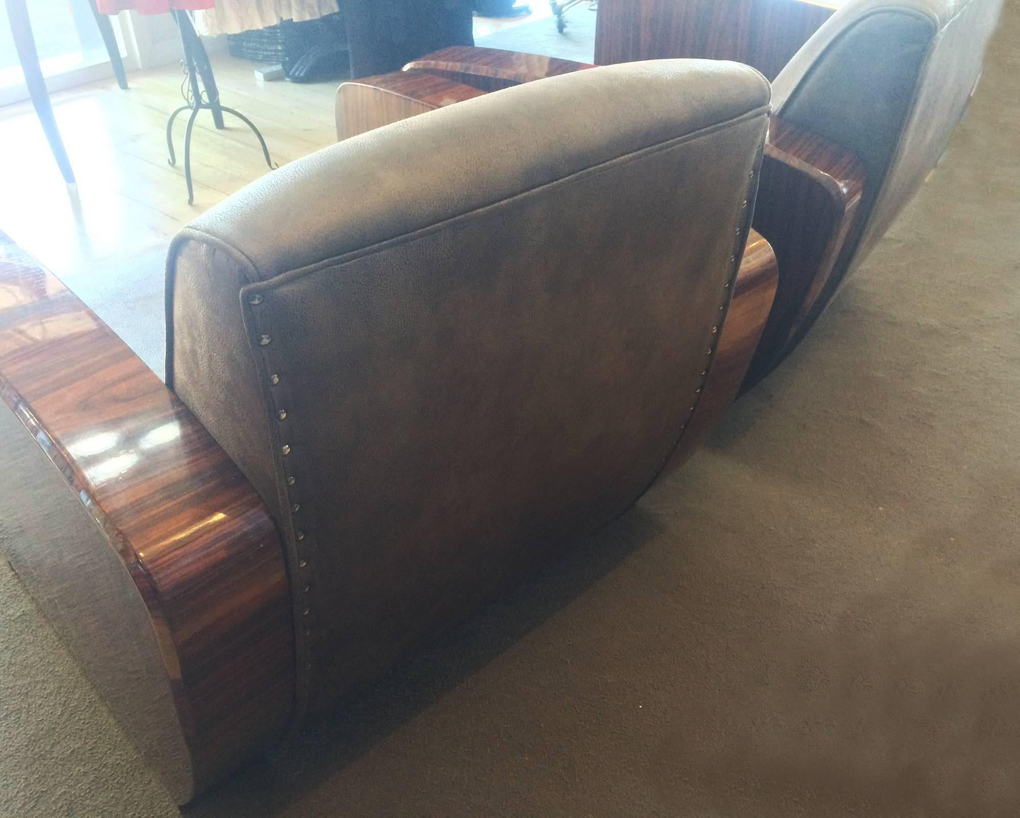 Art Deco style pair of armchairs, very comfortable and fully re-upholstered. The glazed amboyna wood arms and sides are in excellent condition, with a soft, aged patina. Dimensions are approximate: Maximum 82cm wide x 85cm deep x 82cm high back