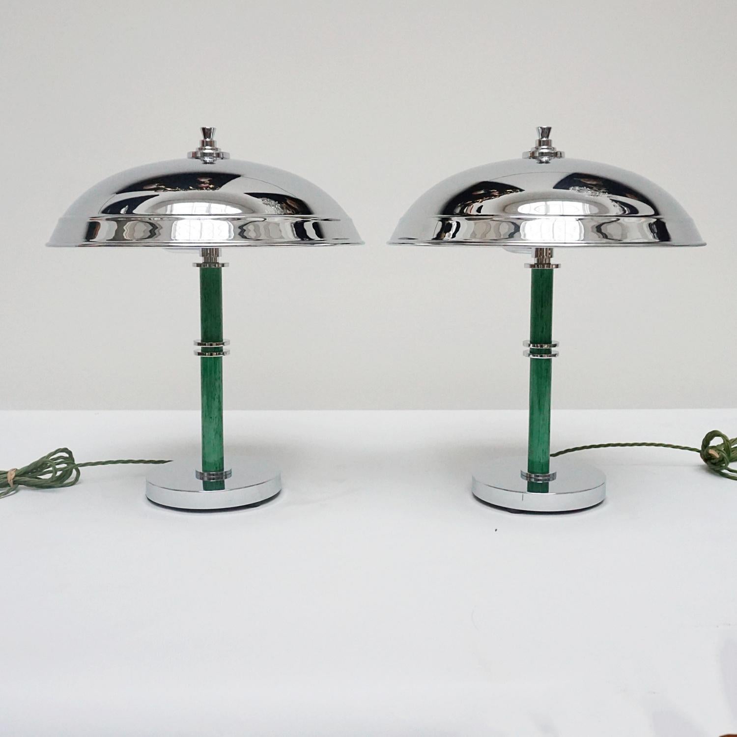 A pair of Art Deco style dome lamps. Mottled green bakelite stem with chrome banding, over a chromed metal circular base and a  chromed metal shade. chrome finial to top. 

Dimensions: H 44cm D of shade 35cm D of base 15cm

Origin: English

Item