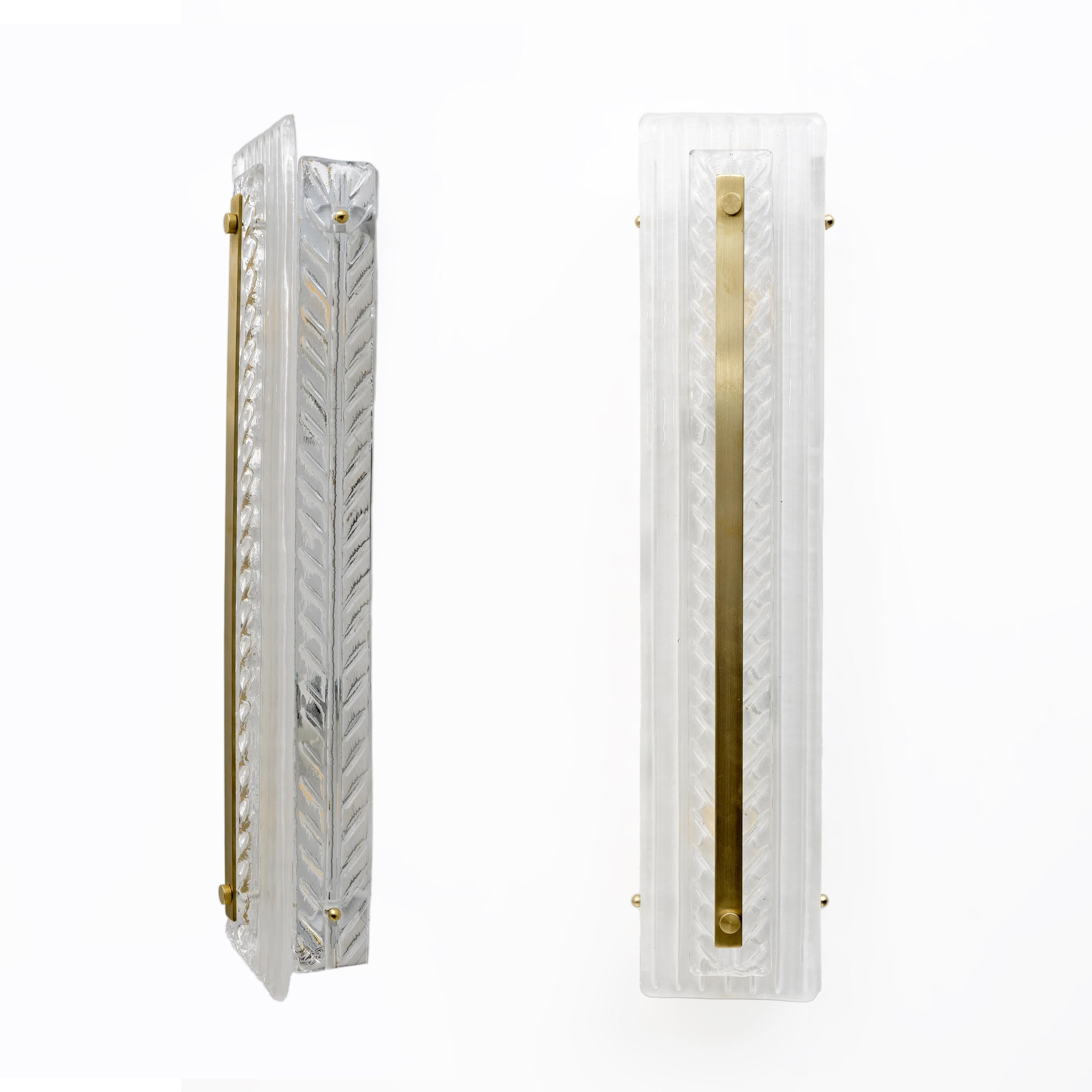 Paire d'appliques en verre texturé de Murano en cristal naturel. Chaque applique comporte trois éléments en verre de Murano avec un motif en chevron et des détails en laiton. Les lampes sont équipées de deux douilles homologuées UL, chacune avec un