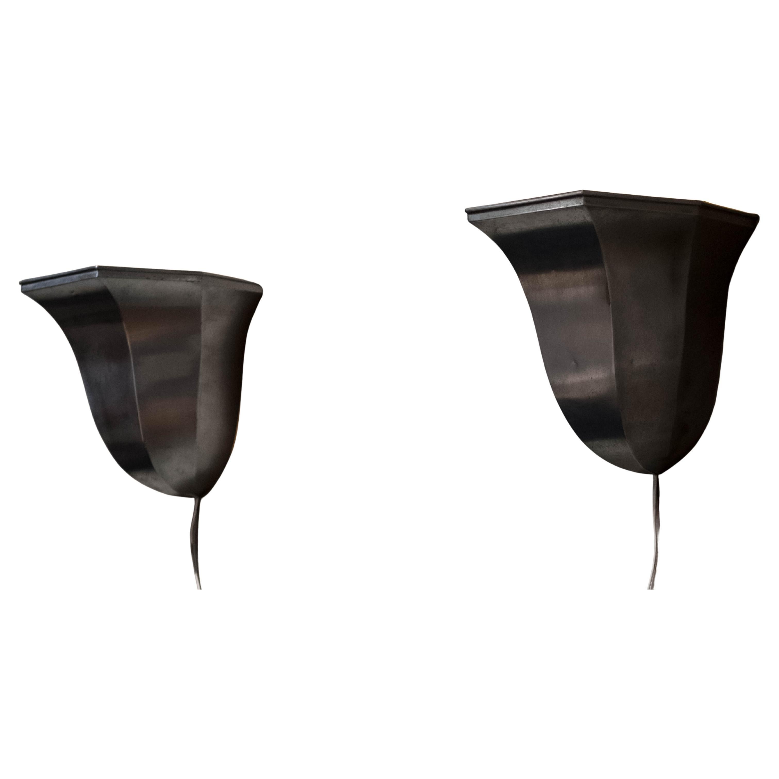 Coppia di applique in metallo spazzolato in stile Art Déco dal design elegante e geometrico. La morbida finitura spazzolata aggiunge una sottile lucentezza, riflettendo la luce in modo meraviglioso.
Le applique sono decorate con linee decise e forme